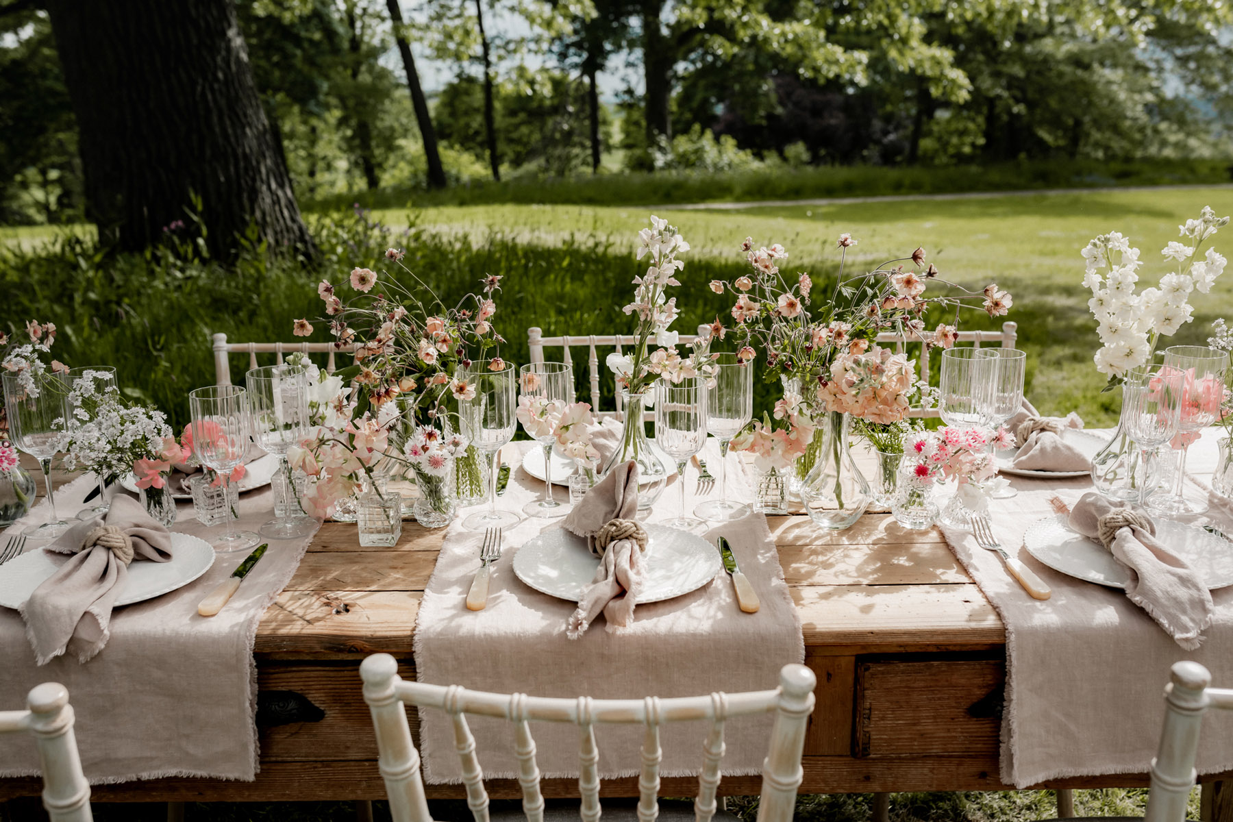 Outdoor wedding table decorated with British grown seasonal Spring flowers and pale table linens