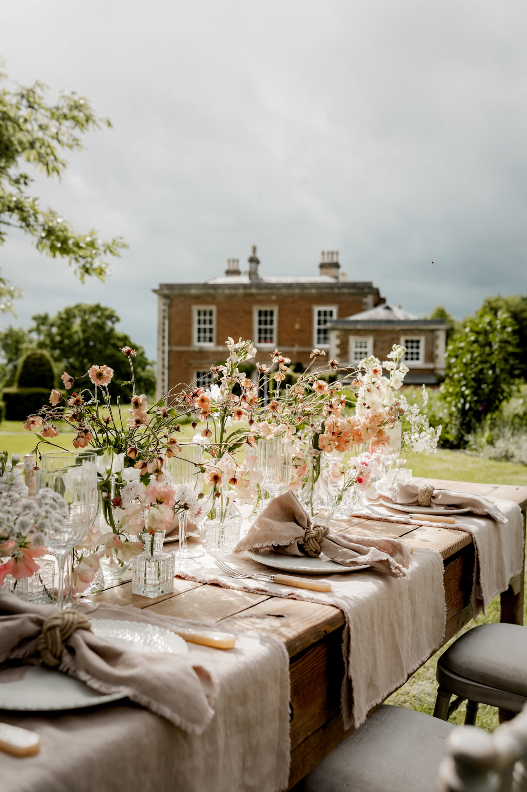 Outdoor wedding table at Keythorpe Hall, decorated with British grown seasonal Spring flowers and pale table linens