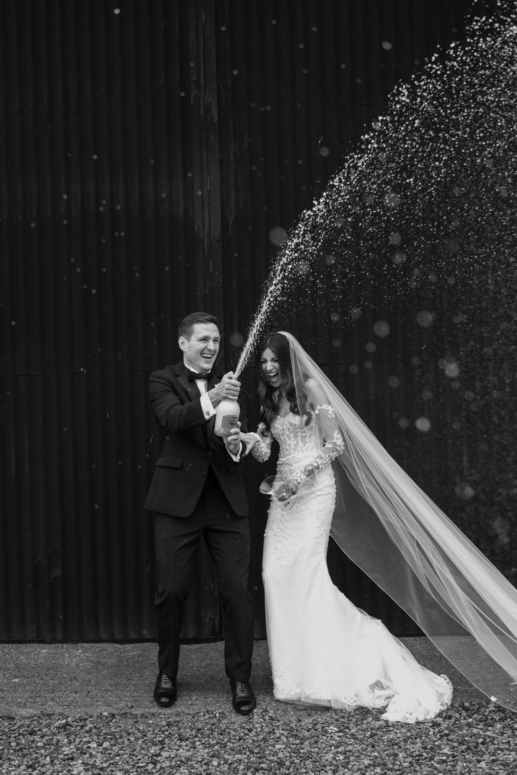 Bride and Groom popping a champagne cork