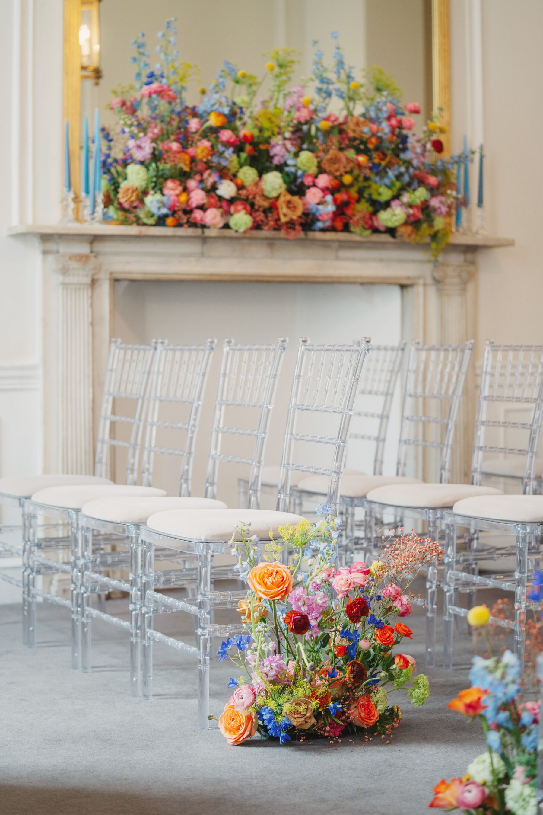 Bright and colourful wedding flowers decorating the end of the aisle and fireplace.