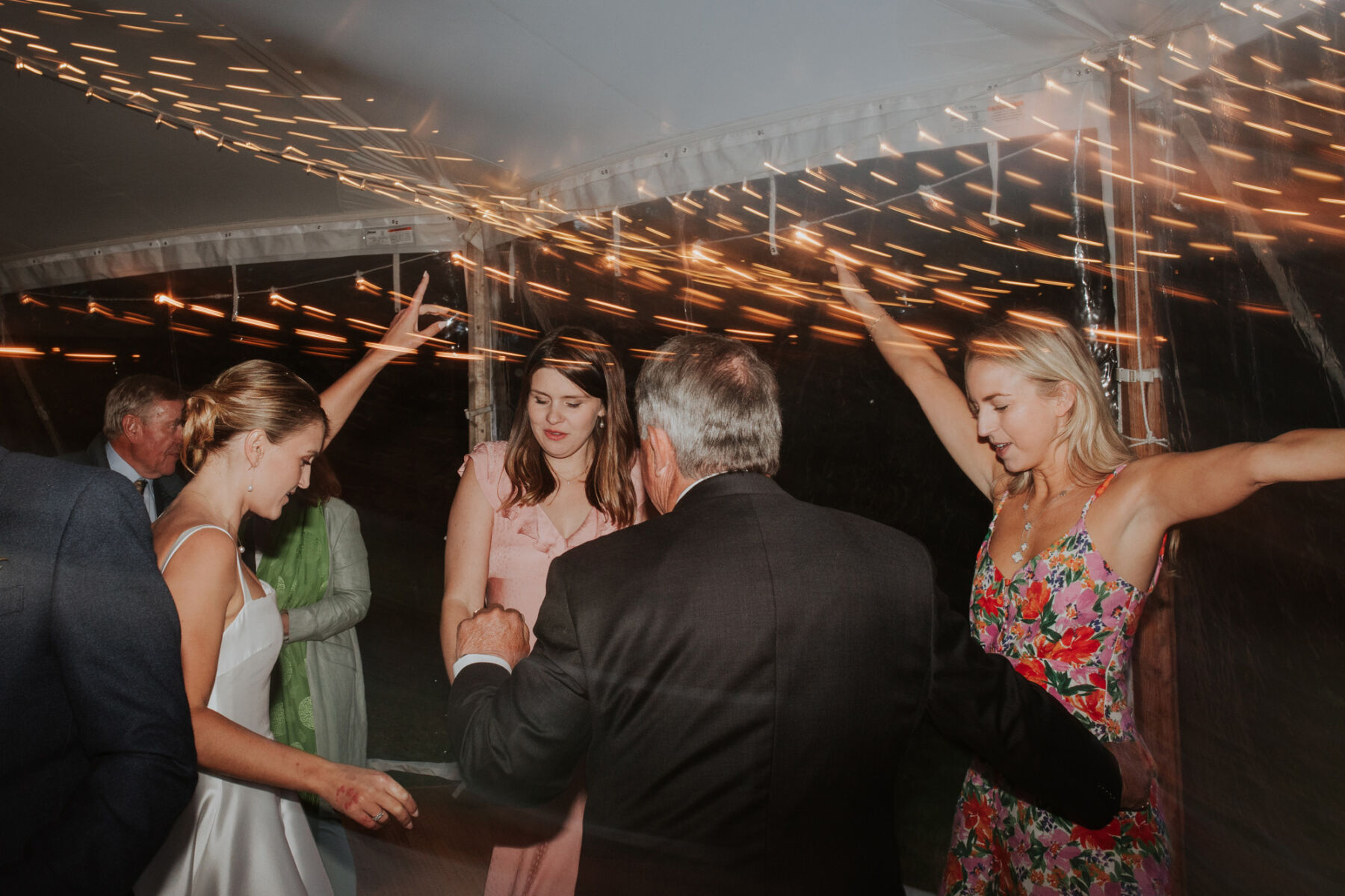 Wedding guests dancing inside a marquee
