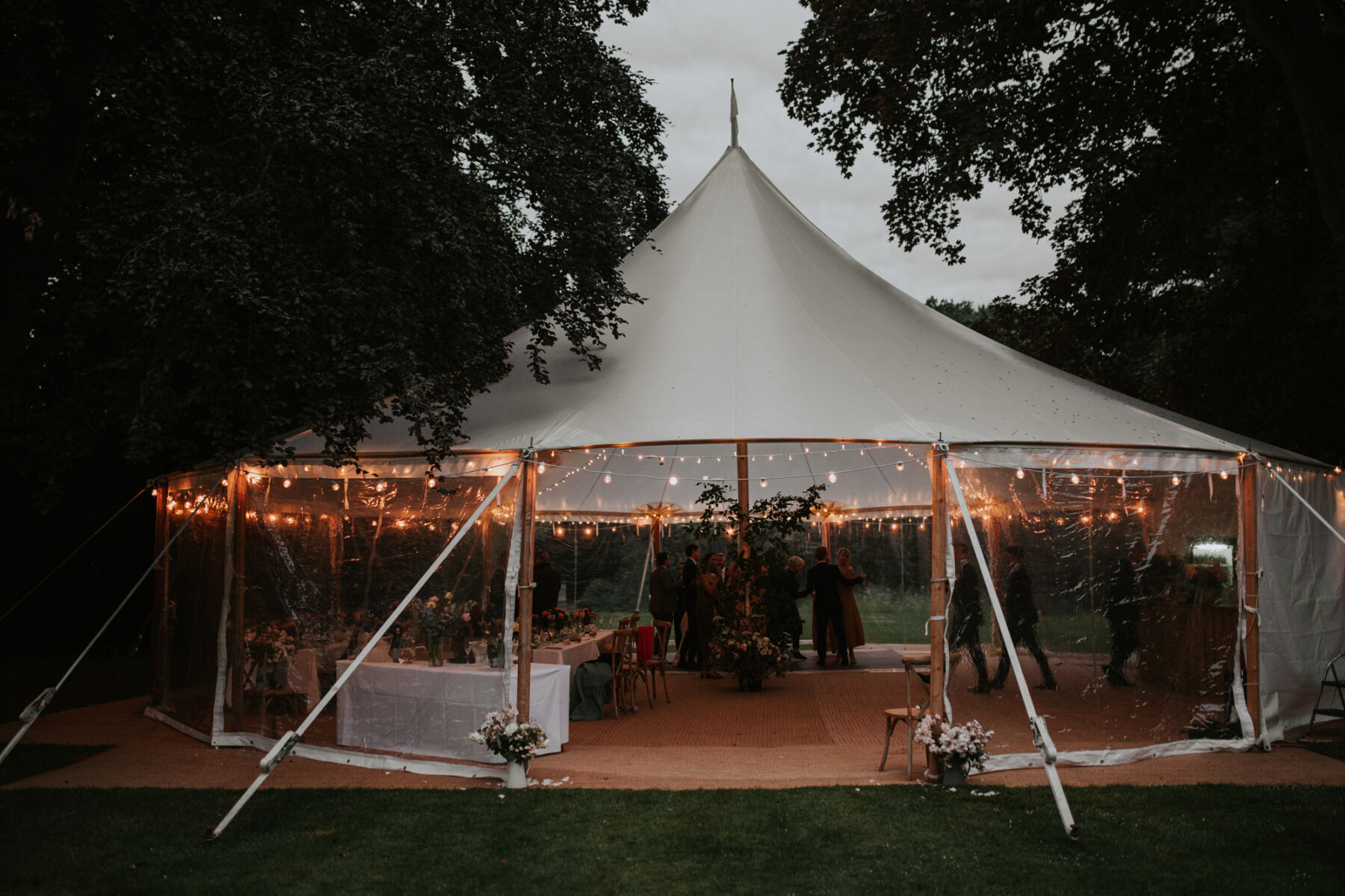 Open sided marquee with festoon lights at dusk.