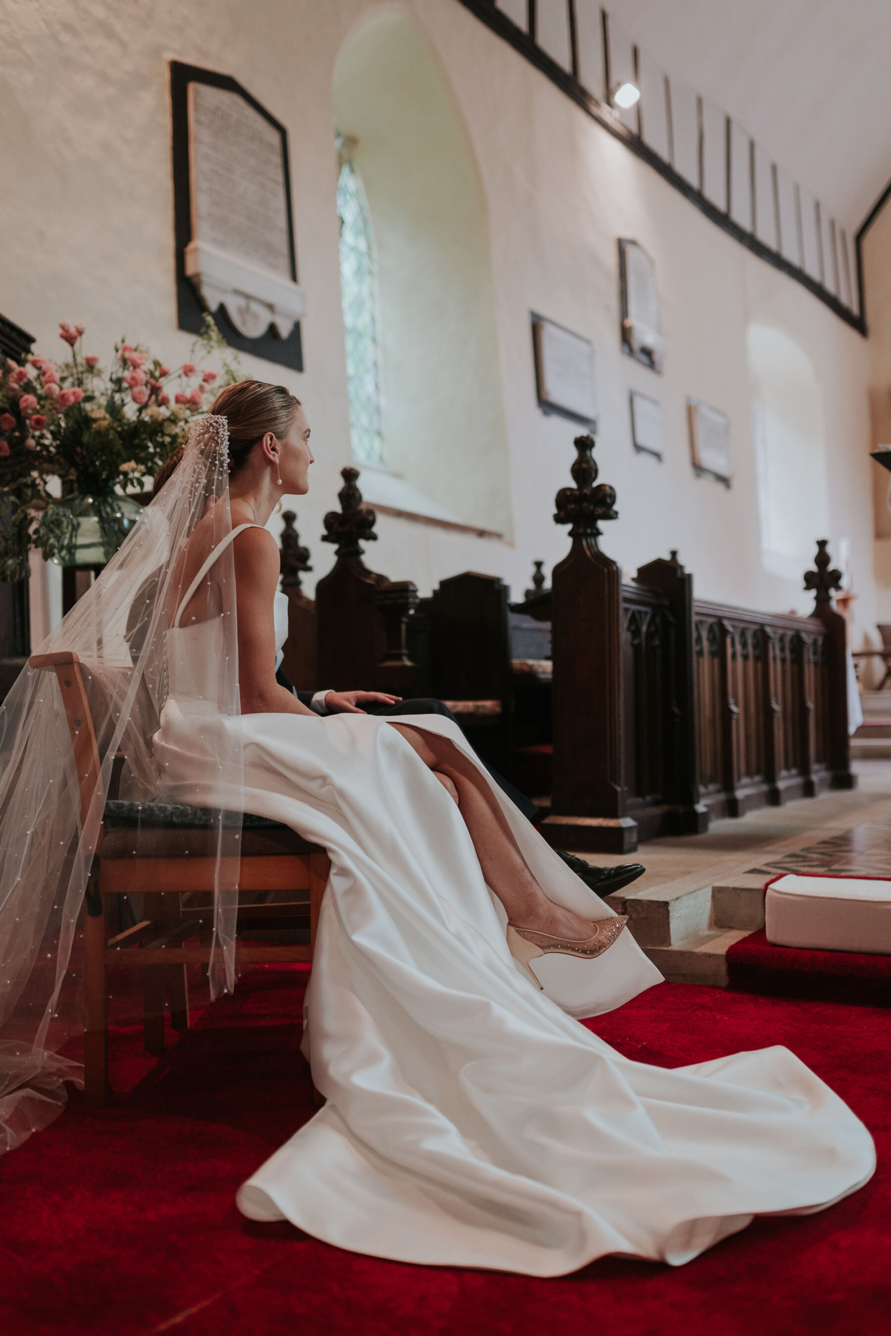 Bride with a polka dot veil and Khya dress with a side slit sat in church curing the ceremony.