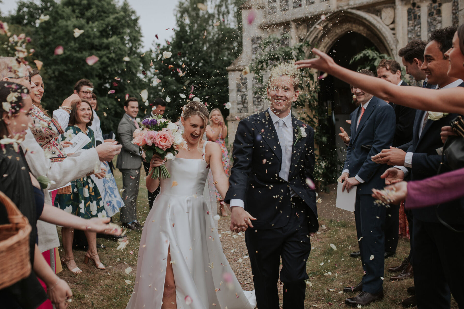 Confetti thrown outside the church, bride and groom laughing