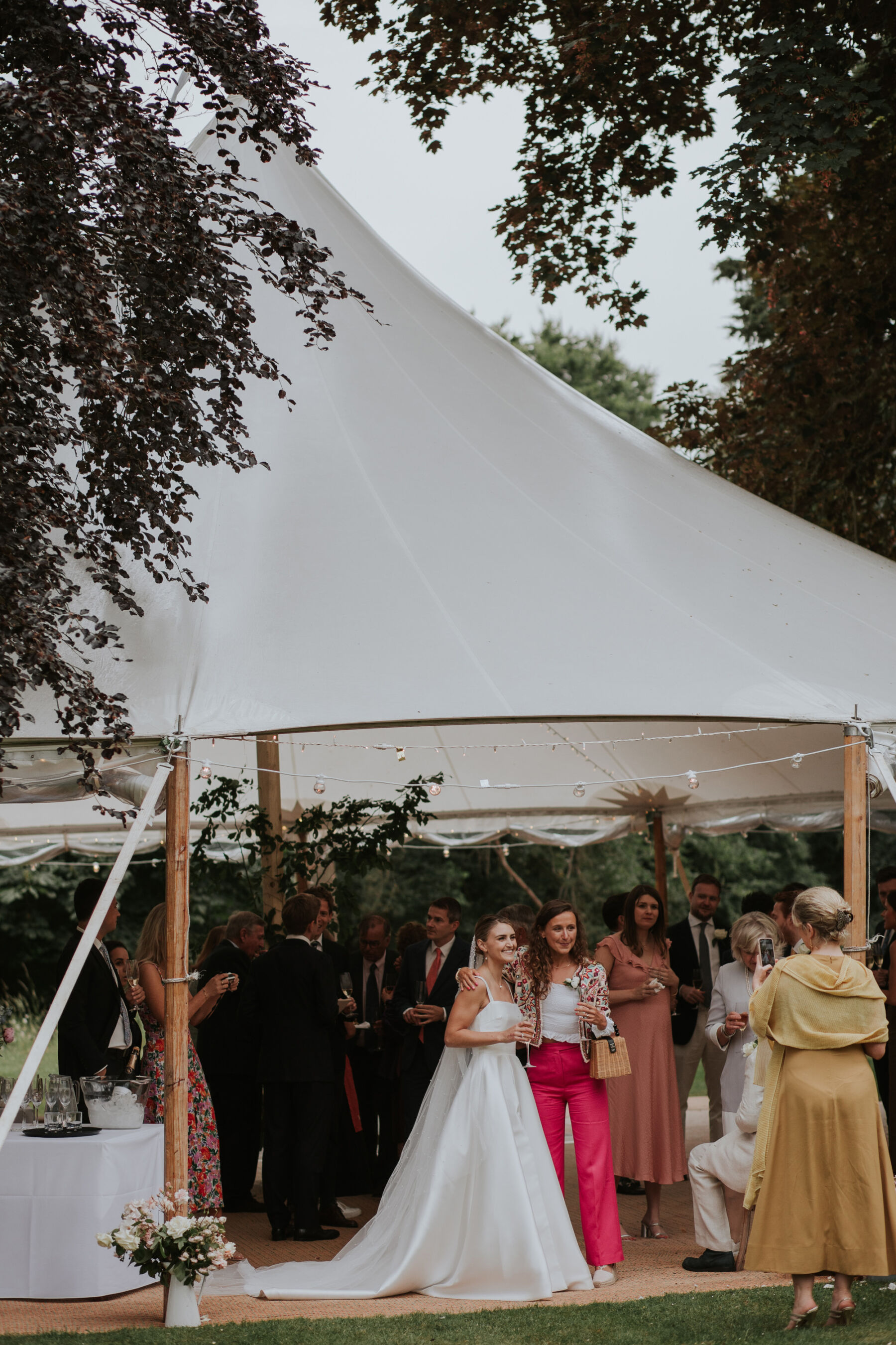 Bride with a wedding guest inside a marquee.