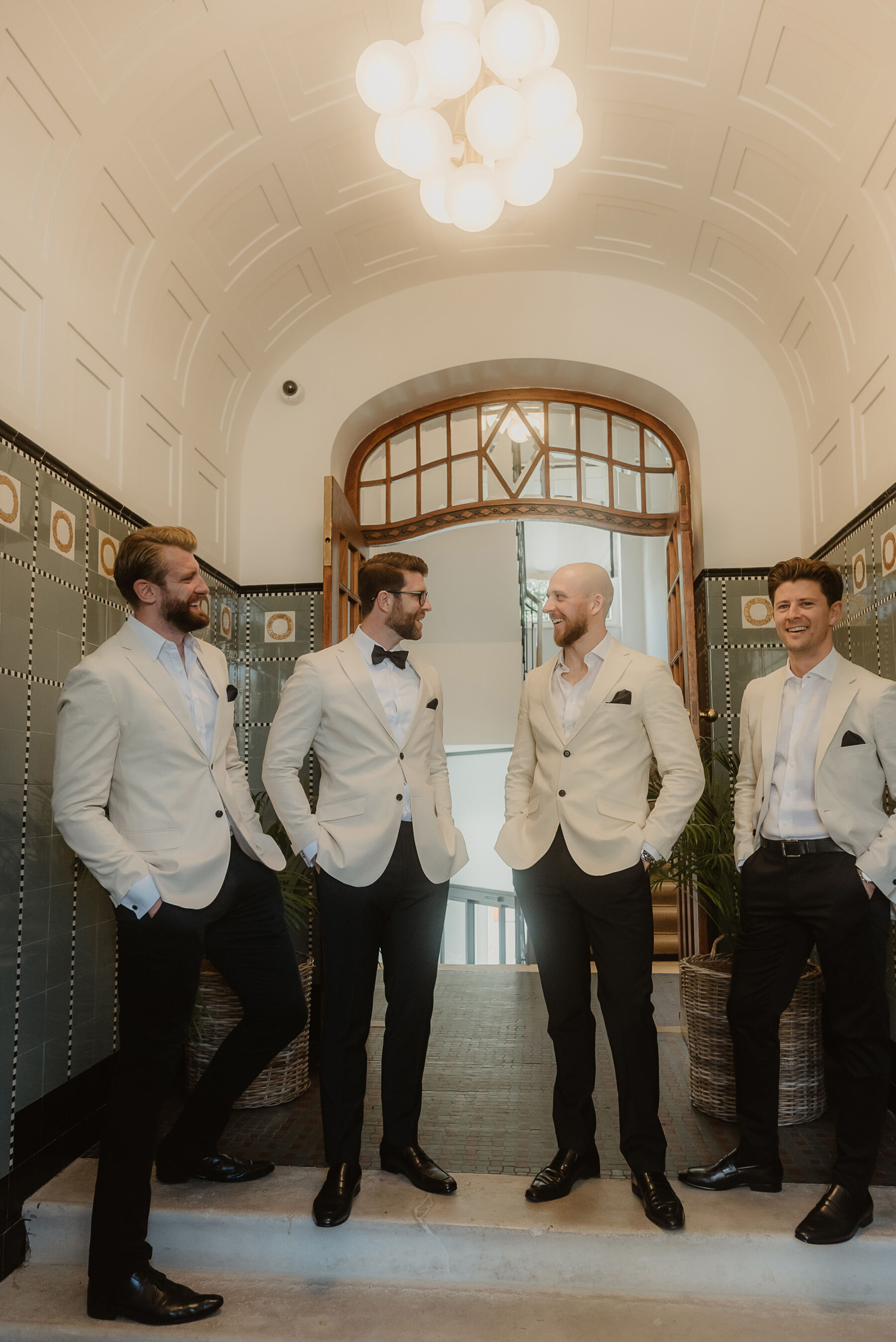 Groom and groomsmen in white tuxedos.