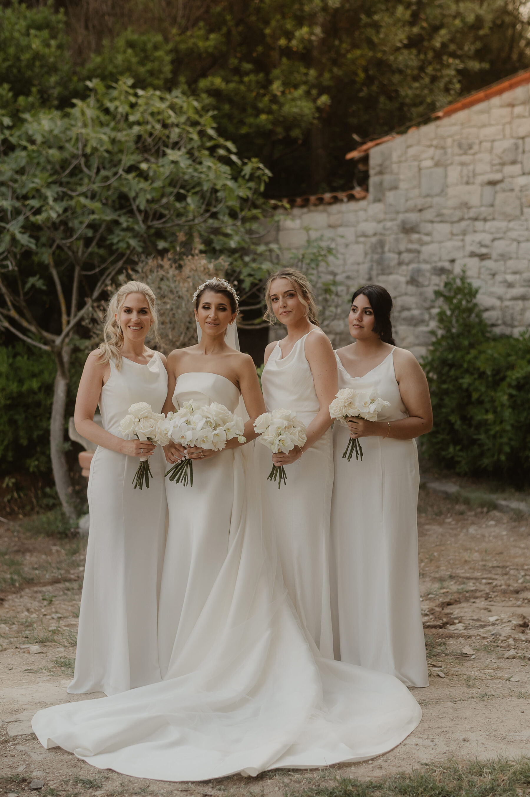 Bridesmaids in white dresses from Chi Chi London. Bride in a modern minimalist wedding dress by Eva Lendel.