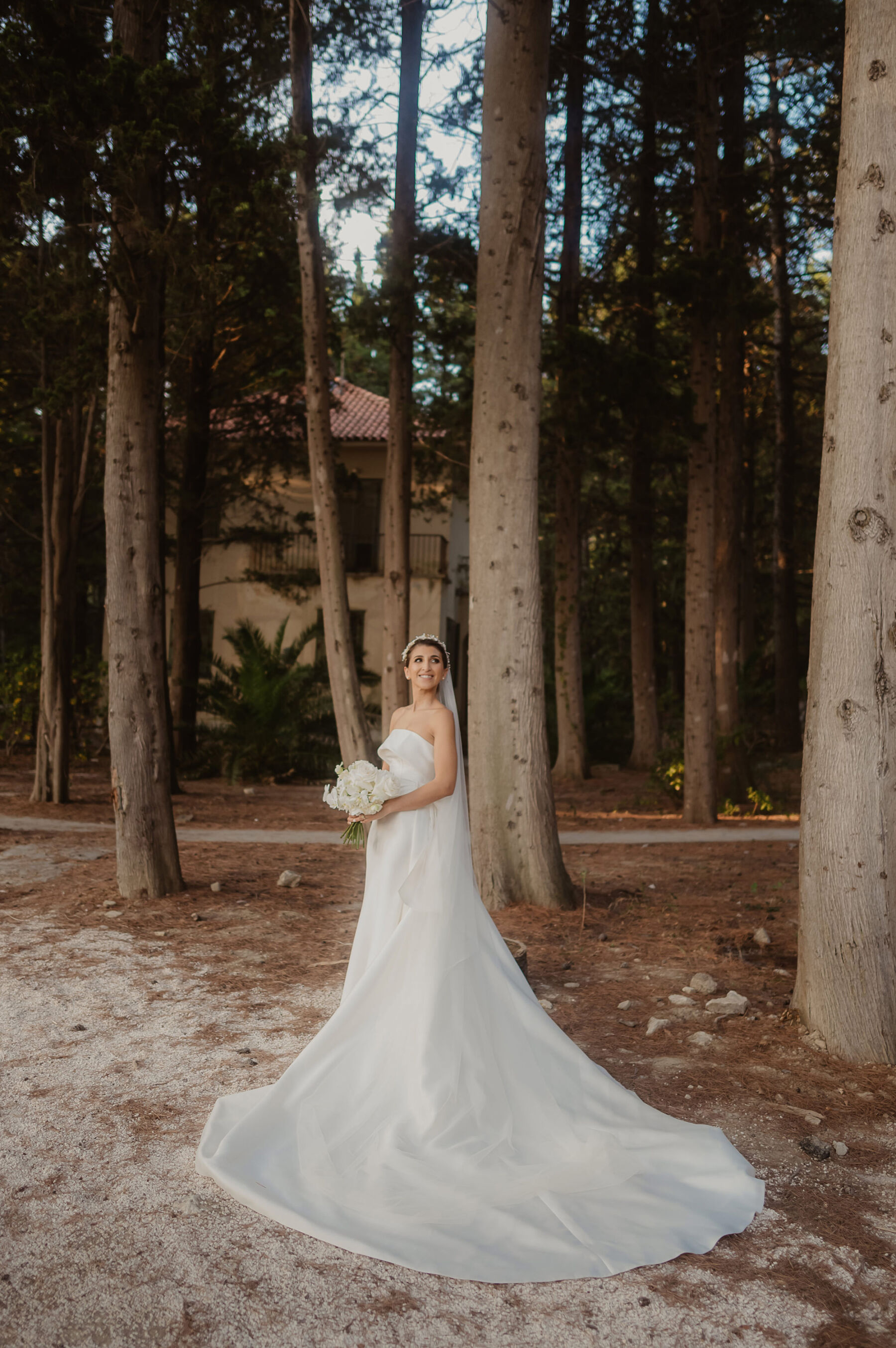 Bride standing in the woods wearing an Eva Lendel modern contemporary wedding dress