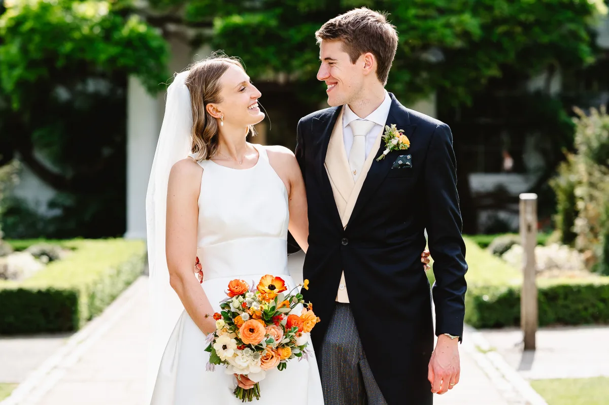 Bride & Groom stand outside Pembroke Lodge in Richmond Park. Looking into each others eyes.