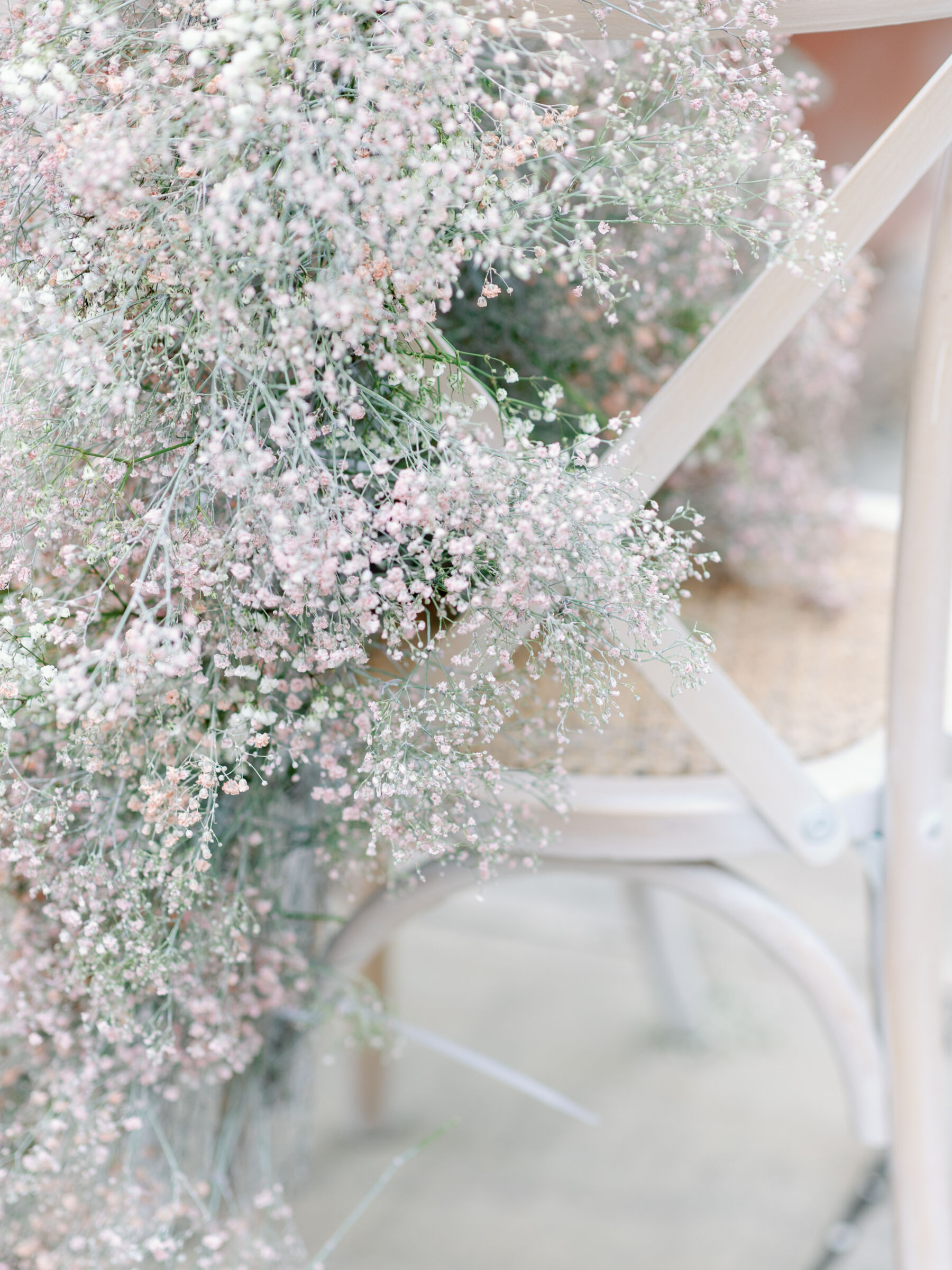 White cross back wedding chair with cascading gypsophila flowers