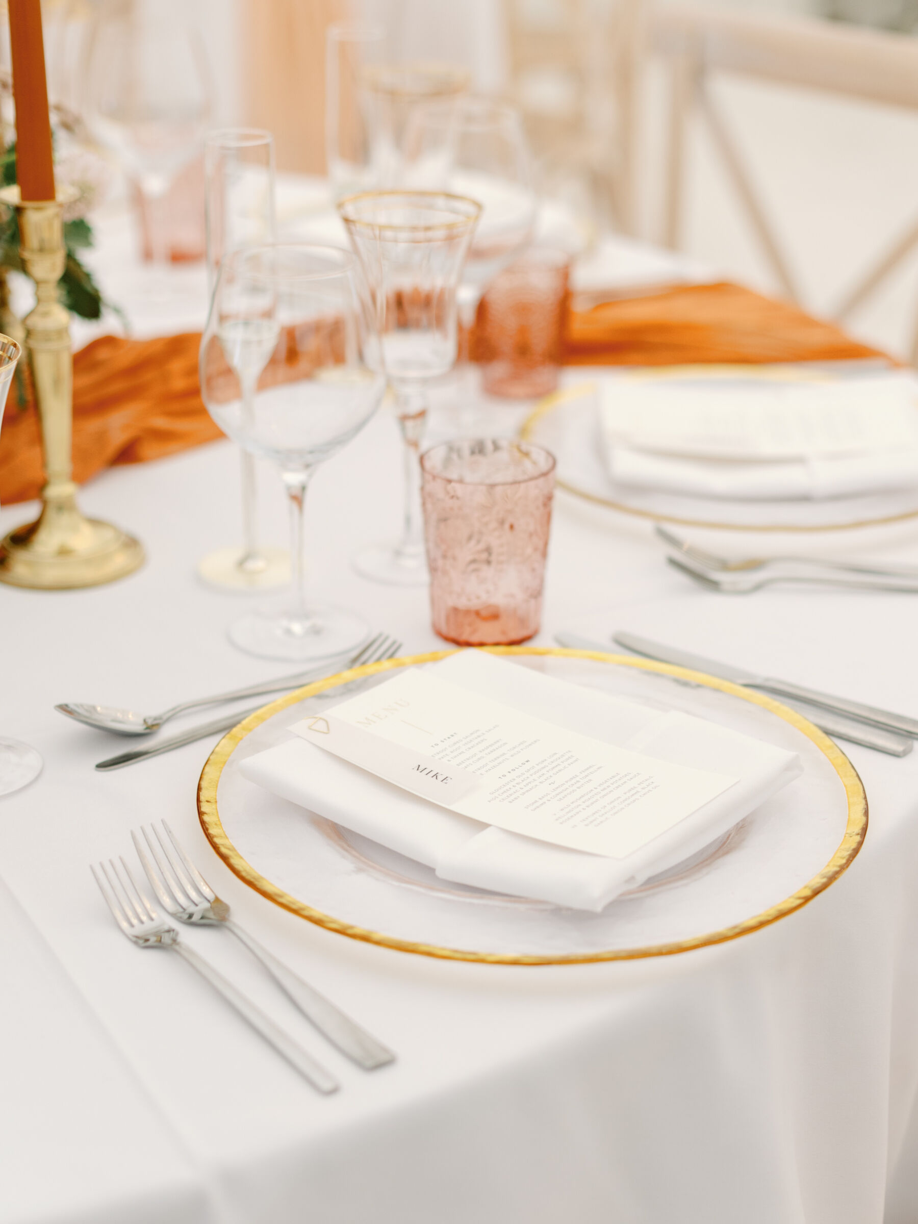 Gold rimmed charger plate at a wedding receptiion.