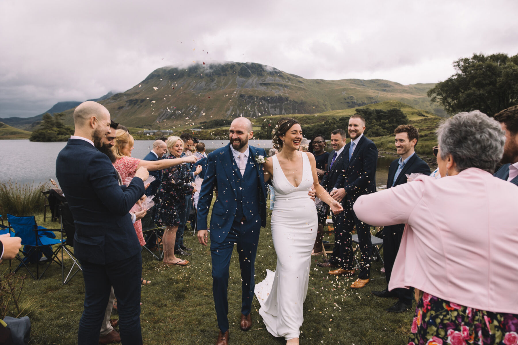 Bride and groom showered in confetti. Outdoor wedding in Wales.