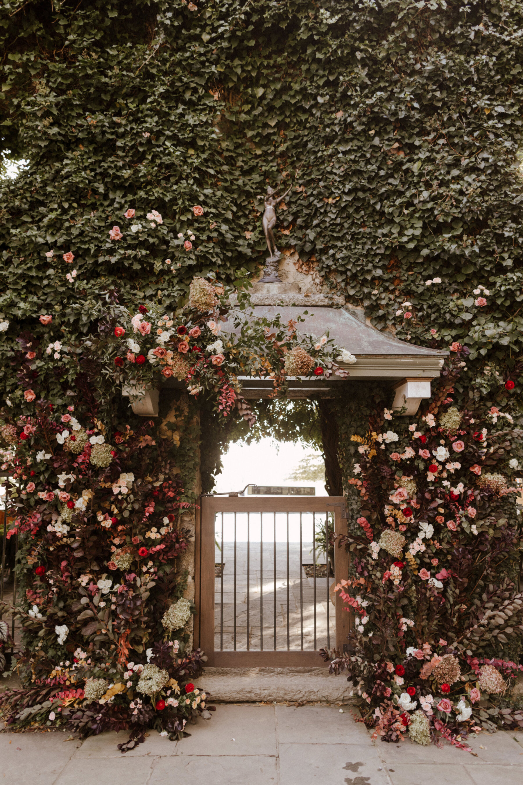 Autumn wedding flowers forming a floral arch.