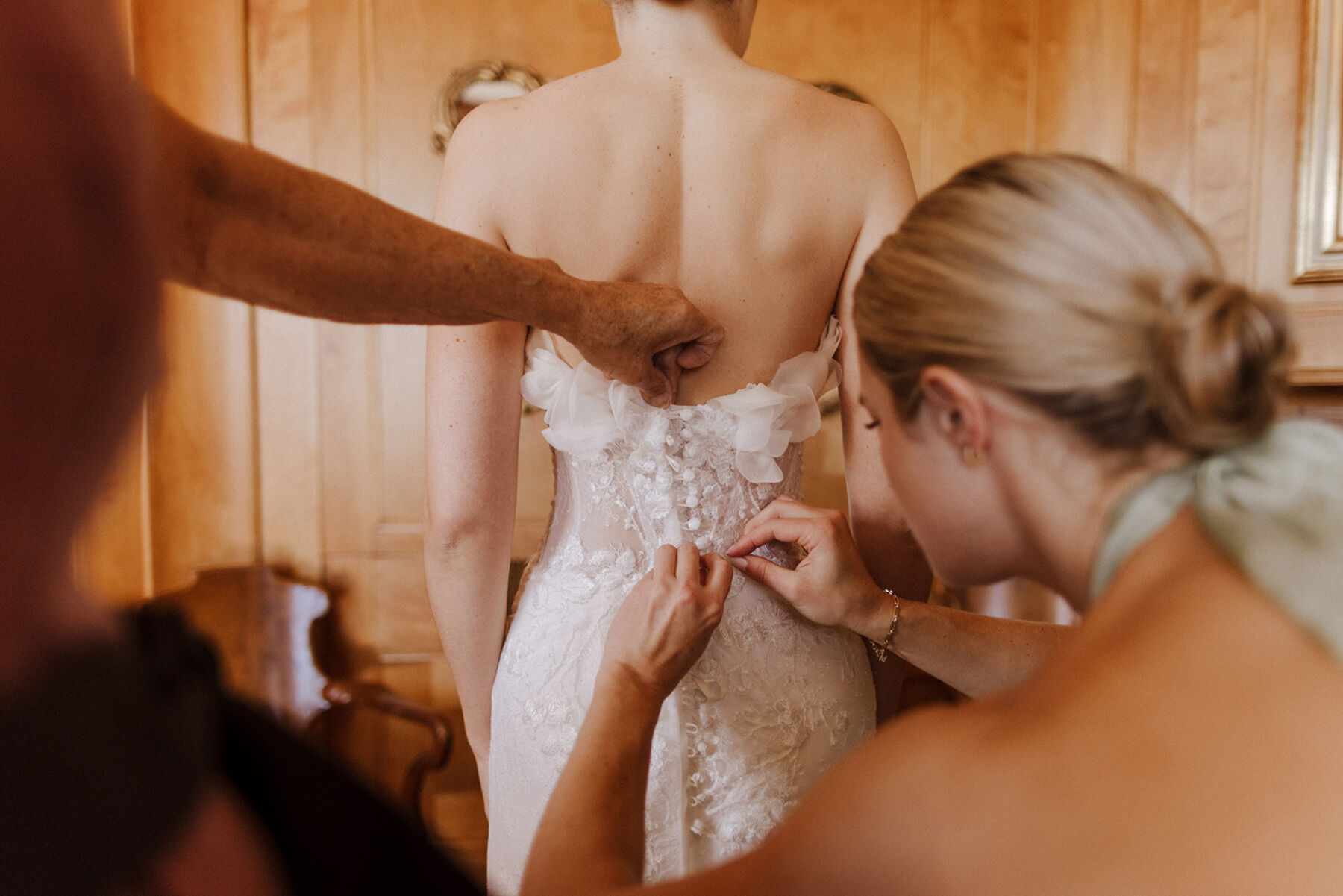 Katie in Sally Bean Couture for her American Wedding Inspired by the Whimsical English Countryside 5 Bride being buttoned in to her Sally Bean Couture wedding dress.