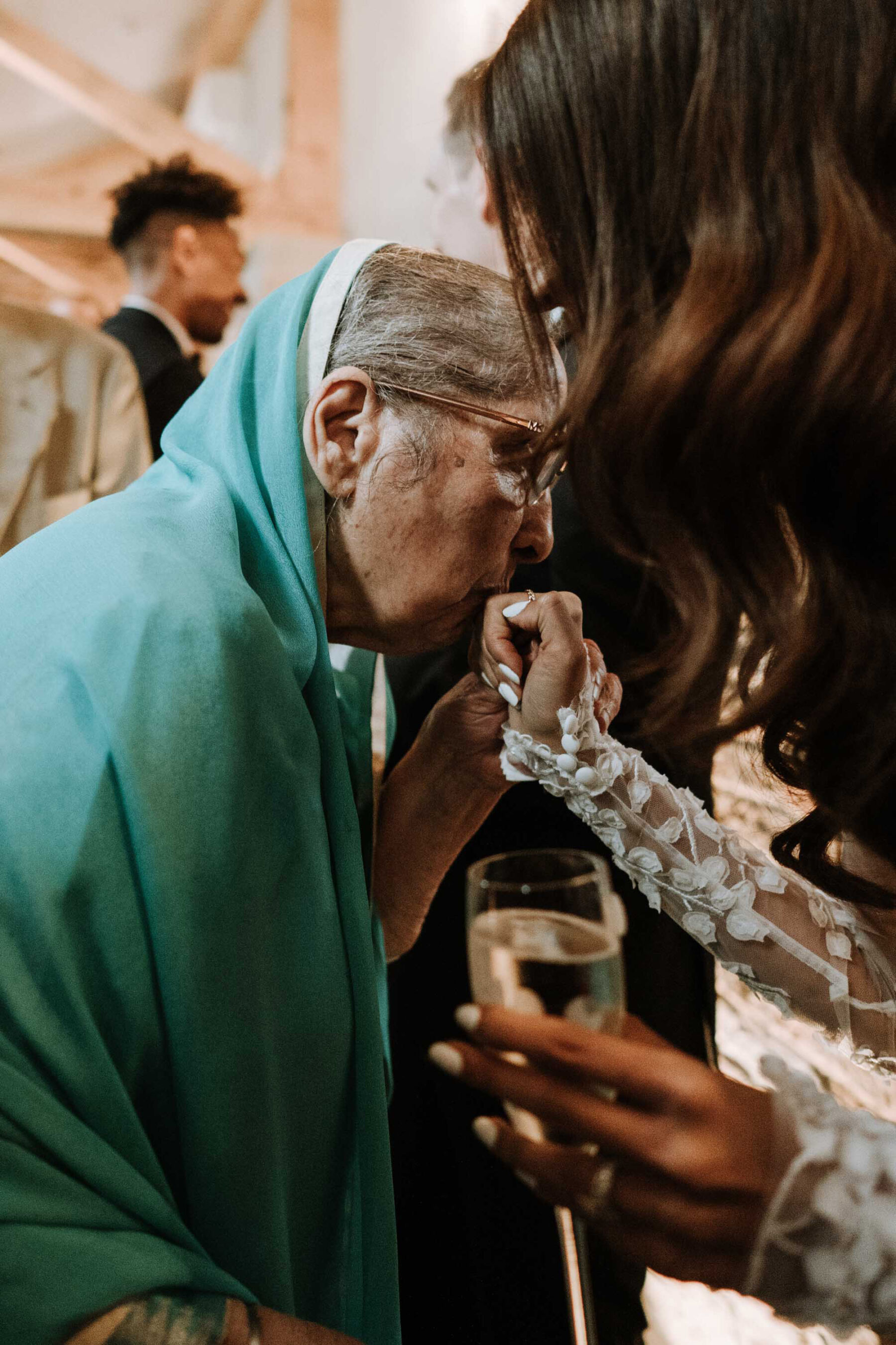 Elderly guest kissing the bride's hand.