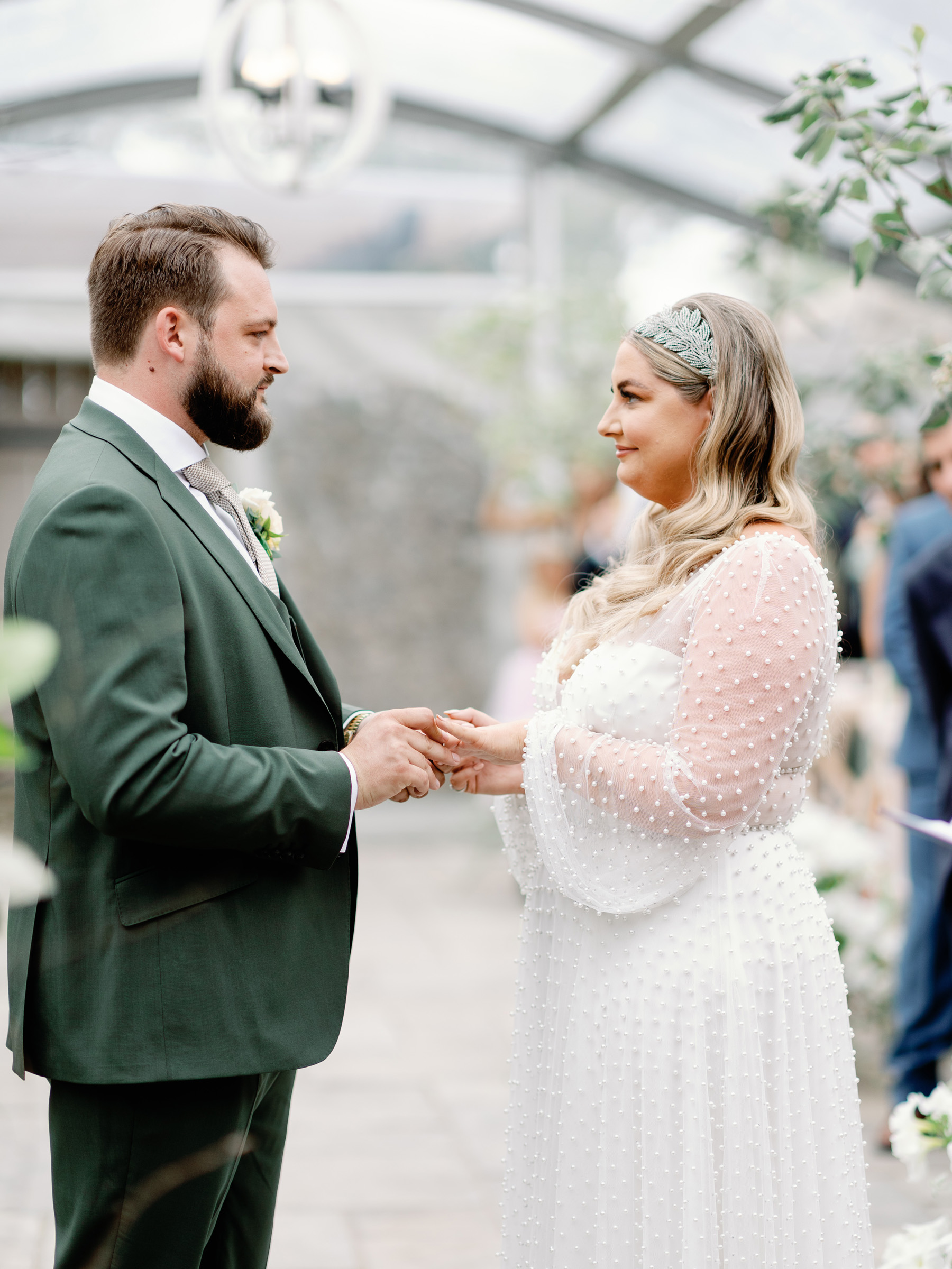 Bride and groom holding hands as they exchange vows during their wedding ceremony, 