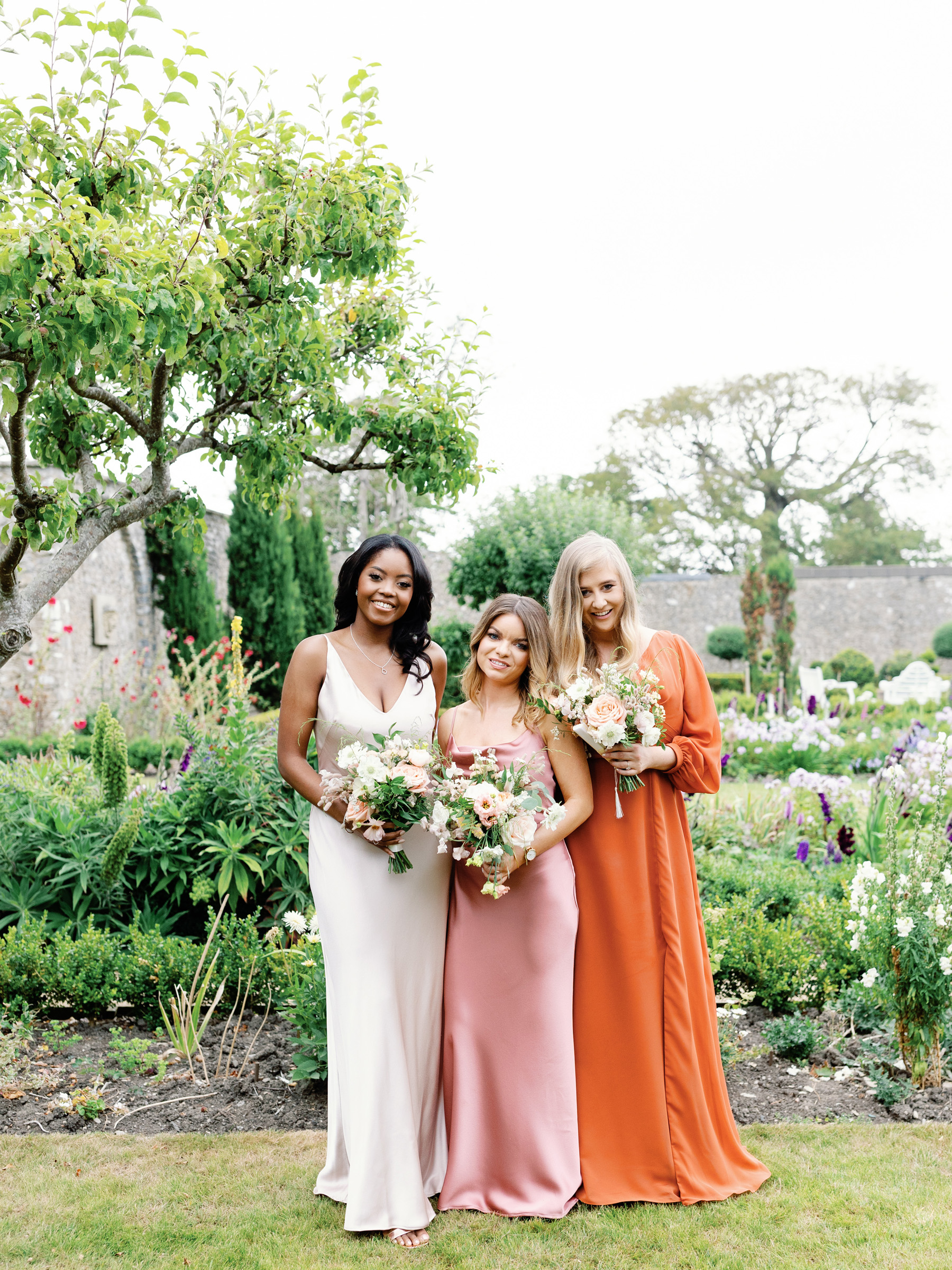 Bridesmaids in pink and burnt orange Jenny Yoo dresses