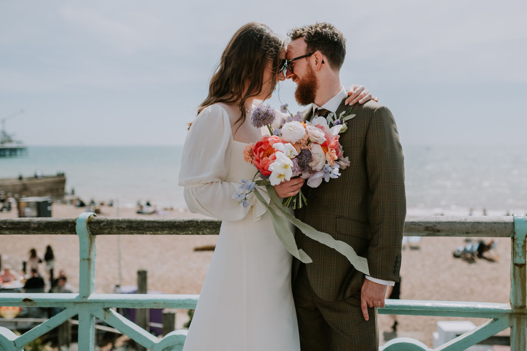 Bride wearing a Reformation wedding dress & carrying a colourful bouquet.