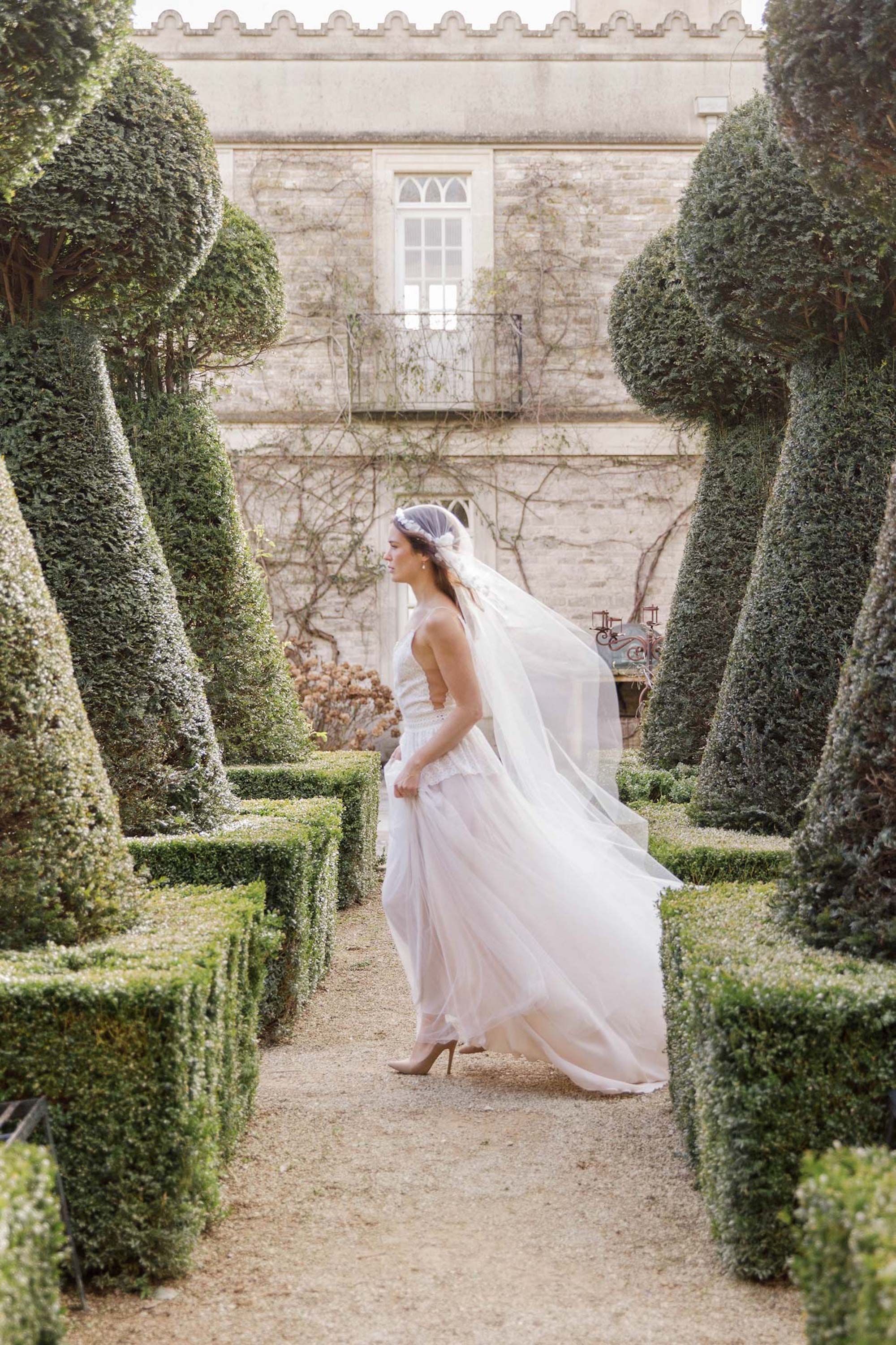 Bride walking through the grounds of Euridge Manor wedding venue, wearing a floaty Juliet Cap wedding veil.