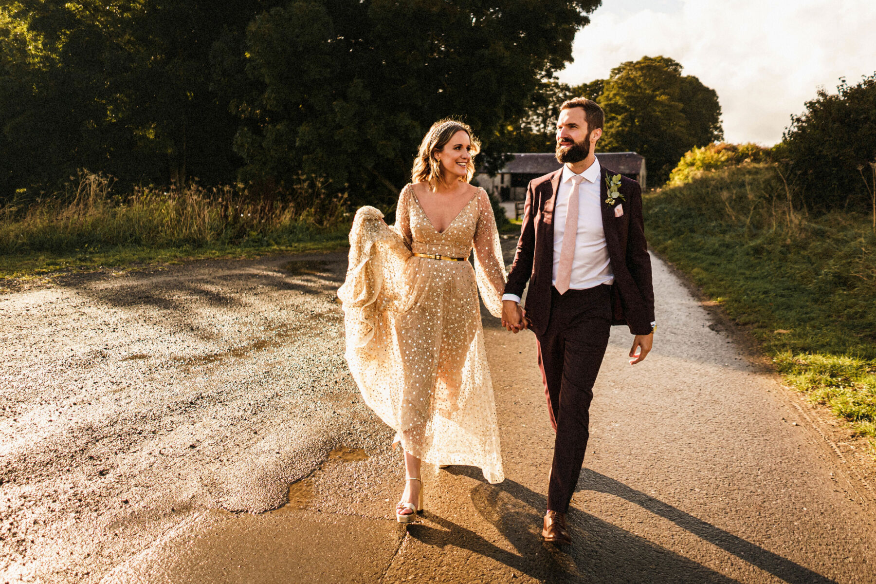 Bride in a gold dress with groom in a burgundy suit and pale pink tie, by Claudia Rose Carter Photography.