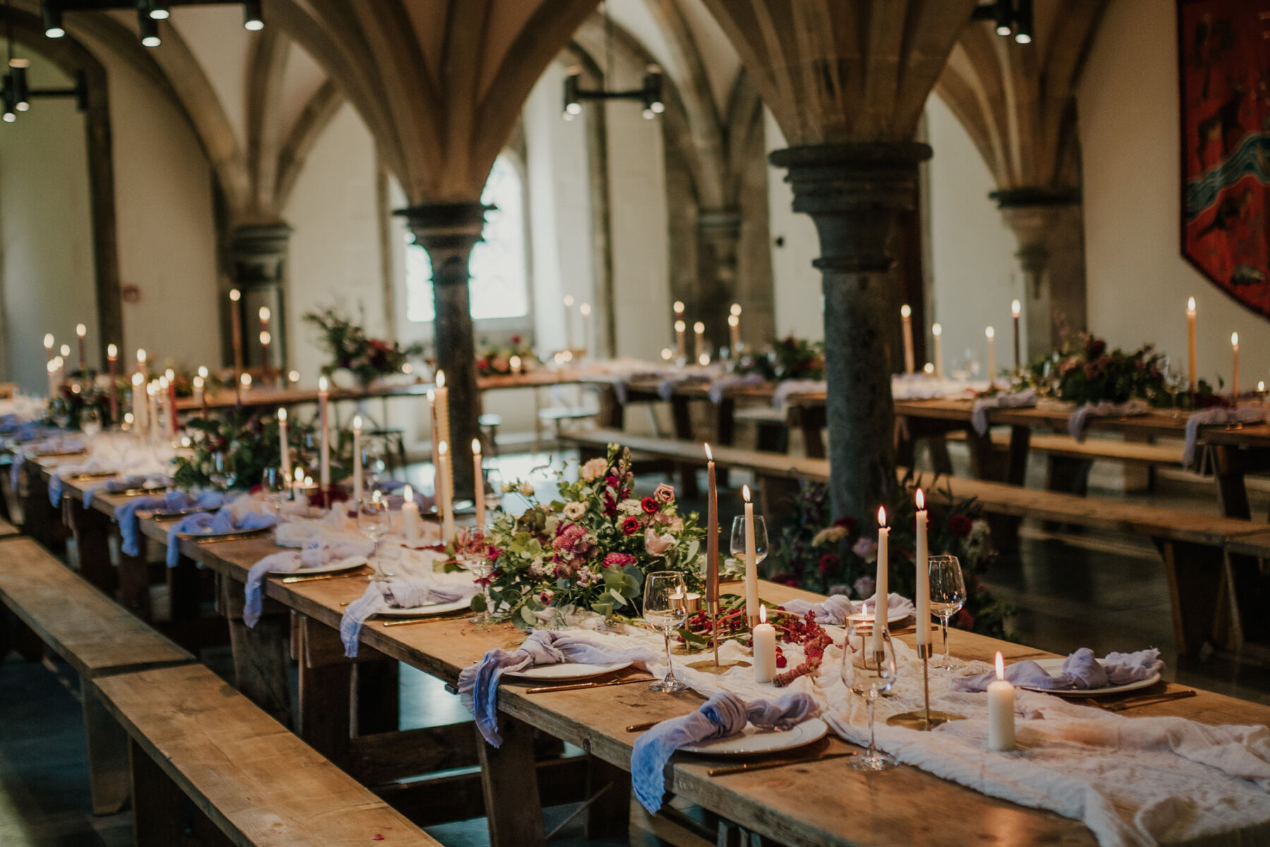 Romantic, candlelit wedding reception on long trestle tables with linen table runners. Bishop's Palace historic wedding venue in Wells, Somerset.