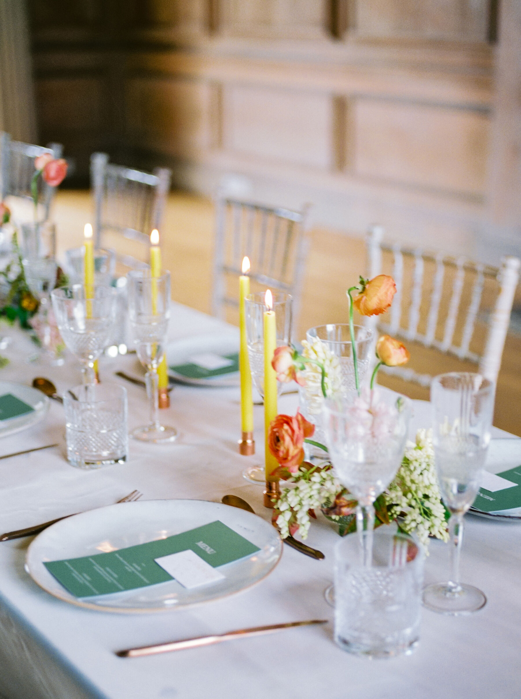 Chatreuse tapered candles on a table with elegant British grown wedding flowers.