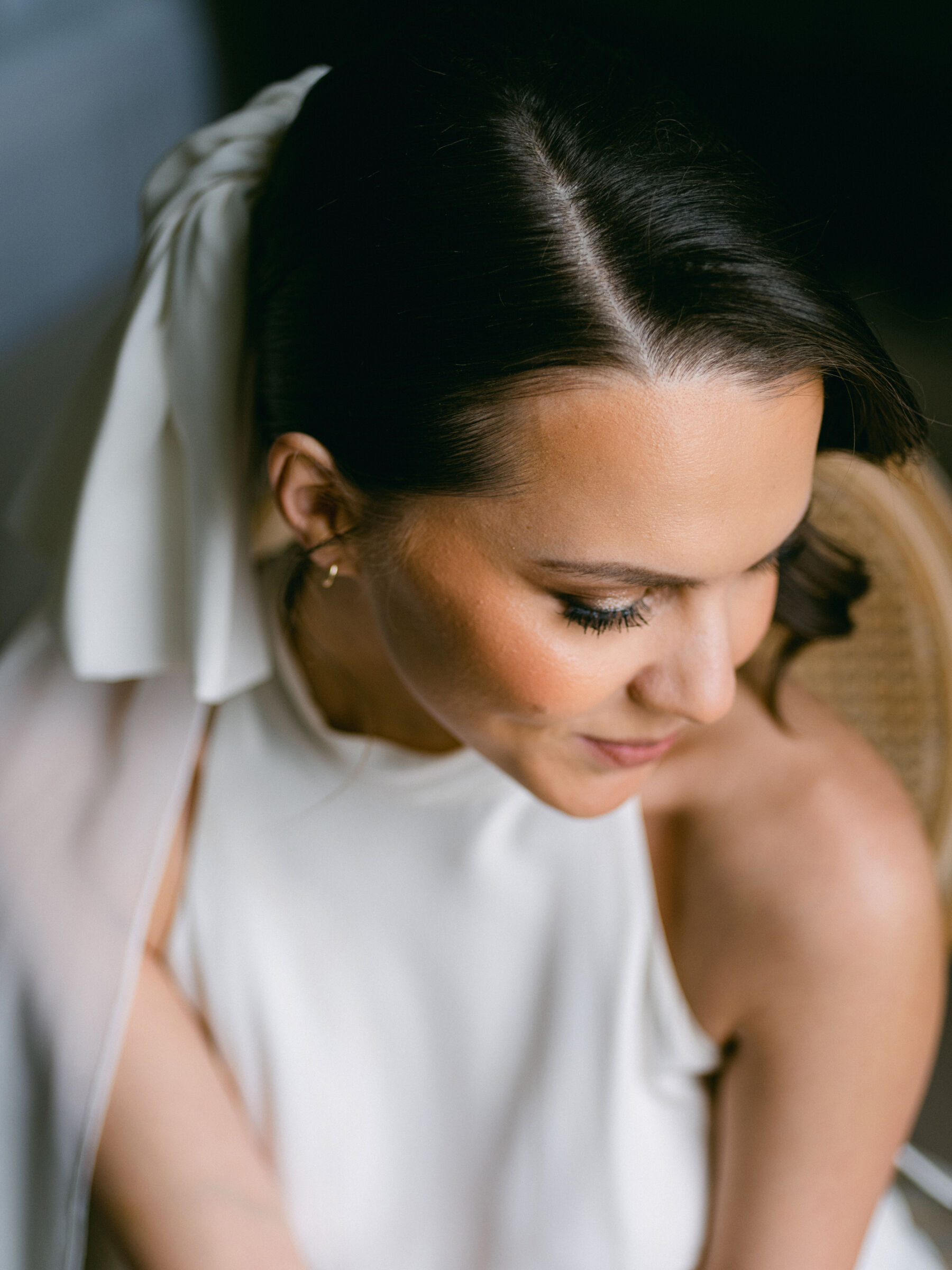 Celebrating Seasonal, British Grown Wedding Flowers With Flower & Fern at Findon Place 20 Portrait of a bride looking down to showcase her elegant wedding day makeup.