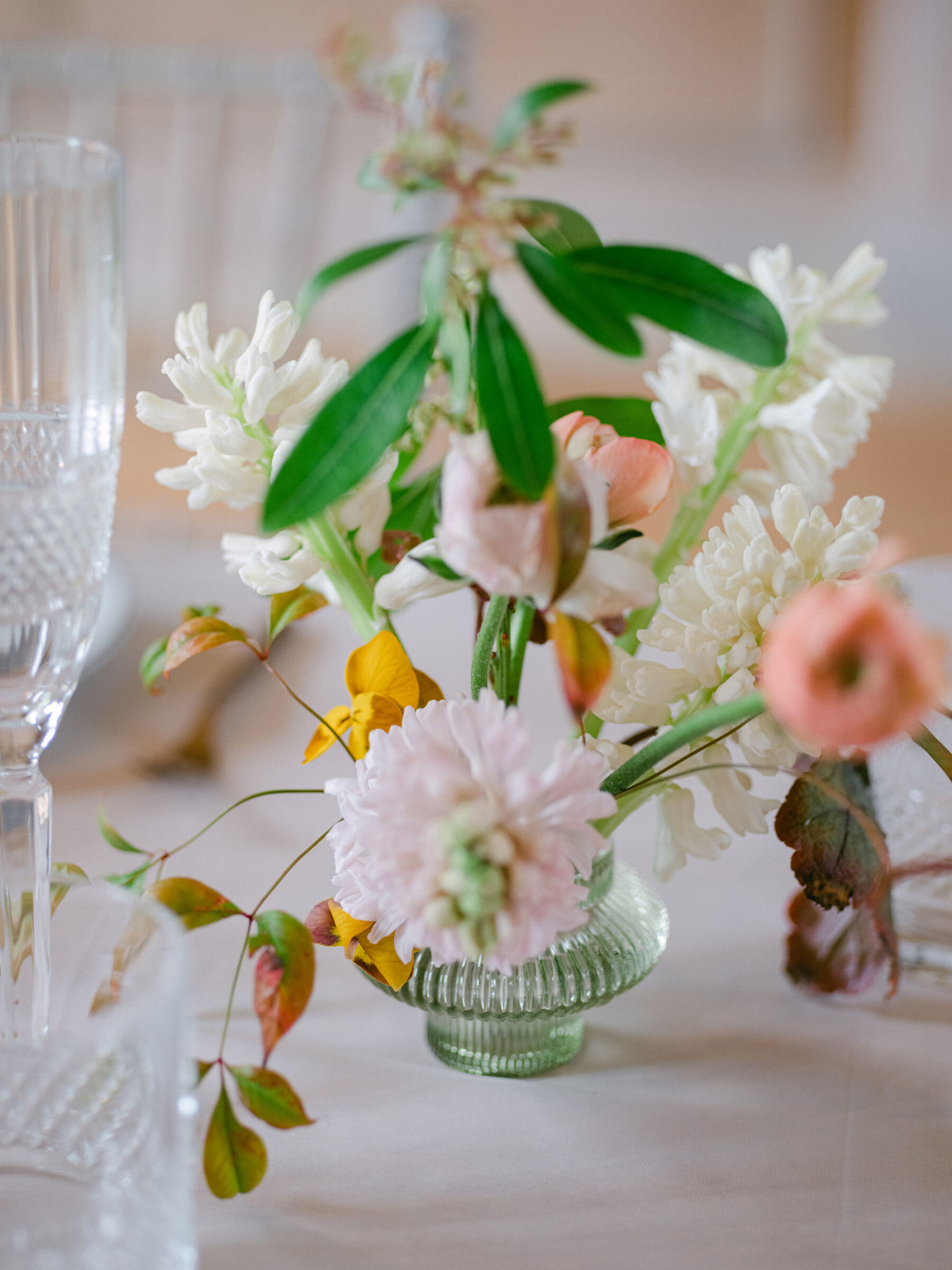 Elegant small ribbed glass vase with a floral frog inside supporting beautiful British grown wedding flowers.