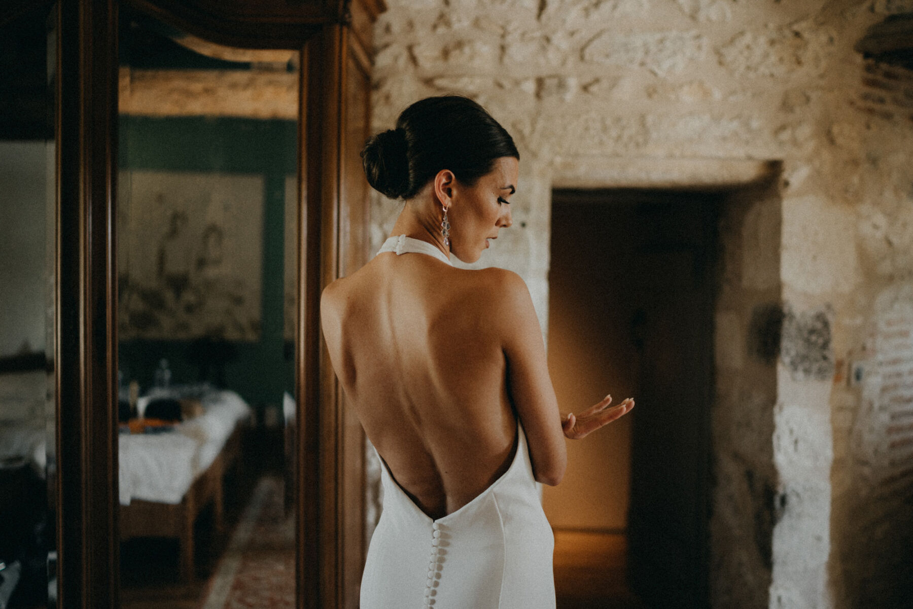 Bride in a sensuous, backless halterneck wedding dress and embroidered veil.