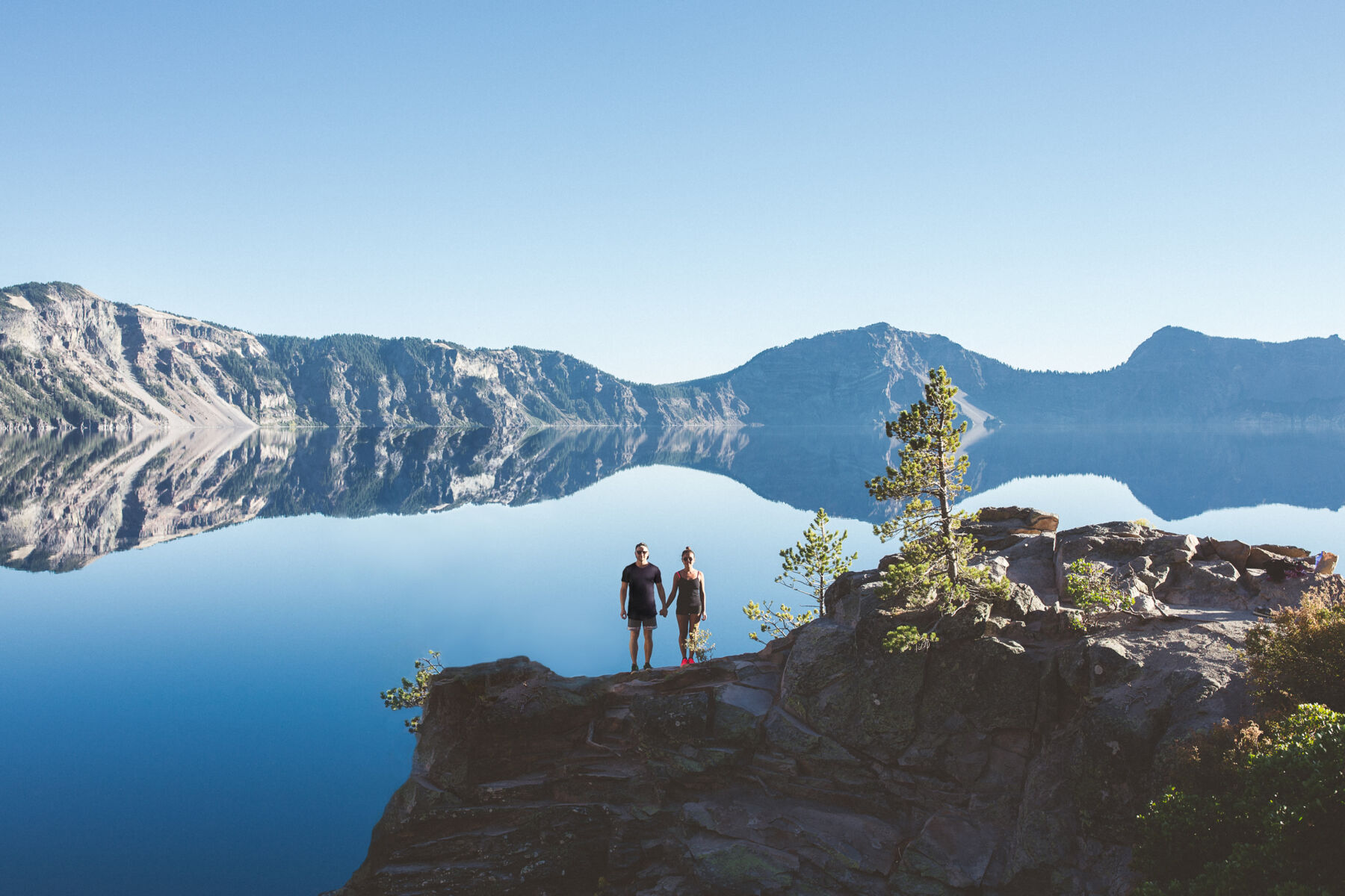 A couple stand at the edge of Crater Lake