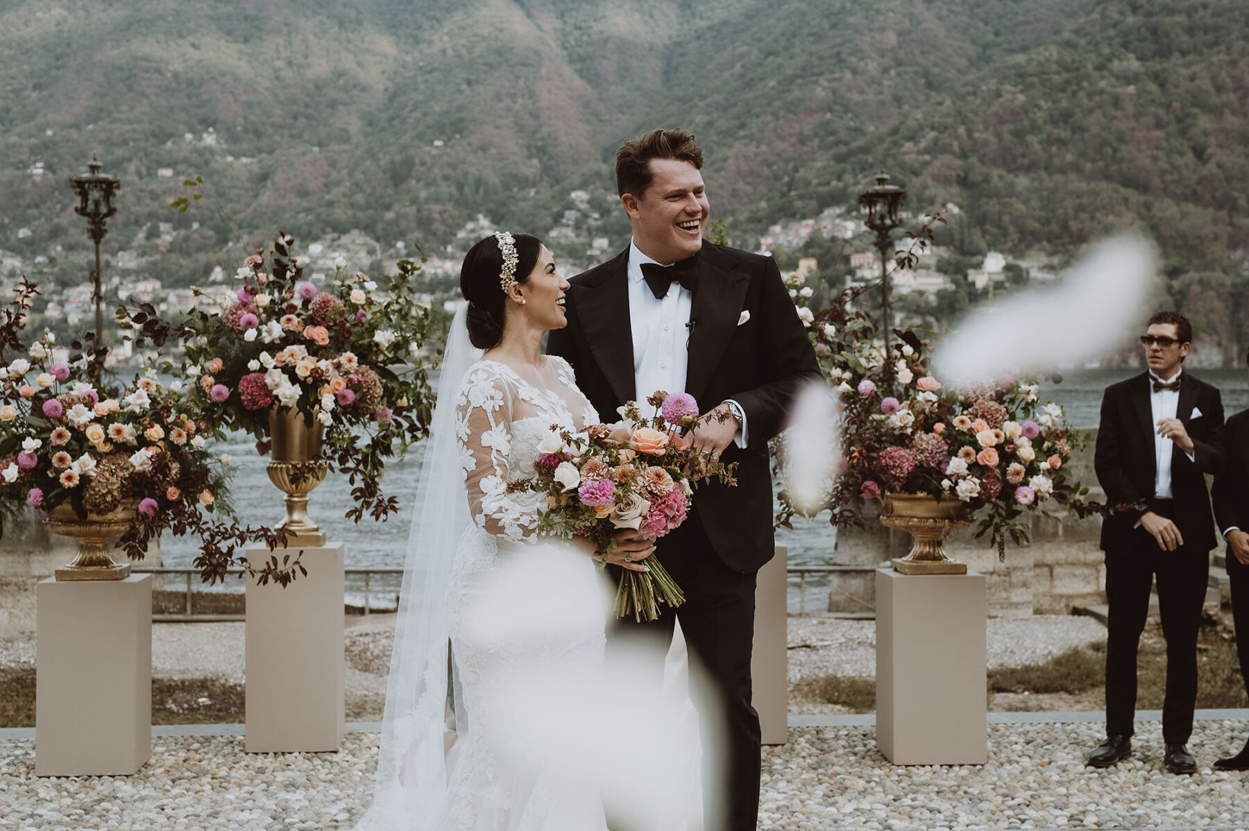 Bride & groom at their wedding ceremony in Lake Como Italy, surrounded by lavish flowers