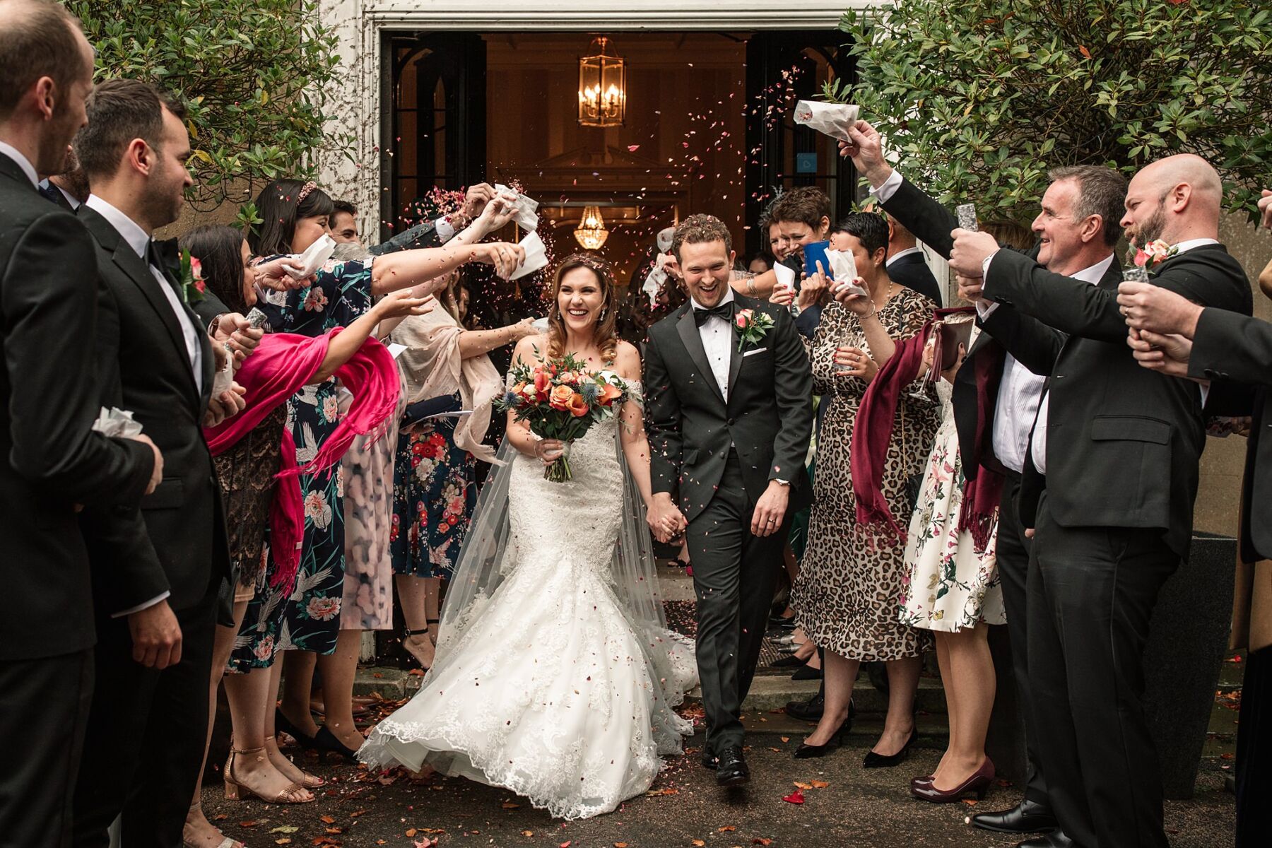 bride and groom at Offley Place walking together amongst guests who are throwing confetti. photo taken by Becky Harley Photography