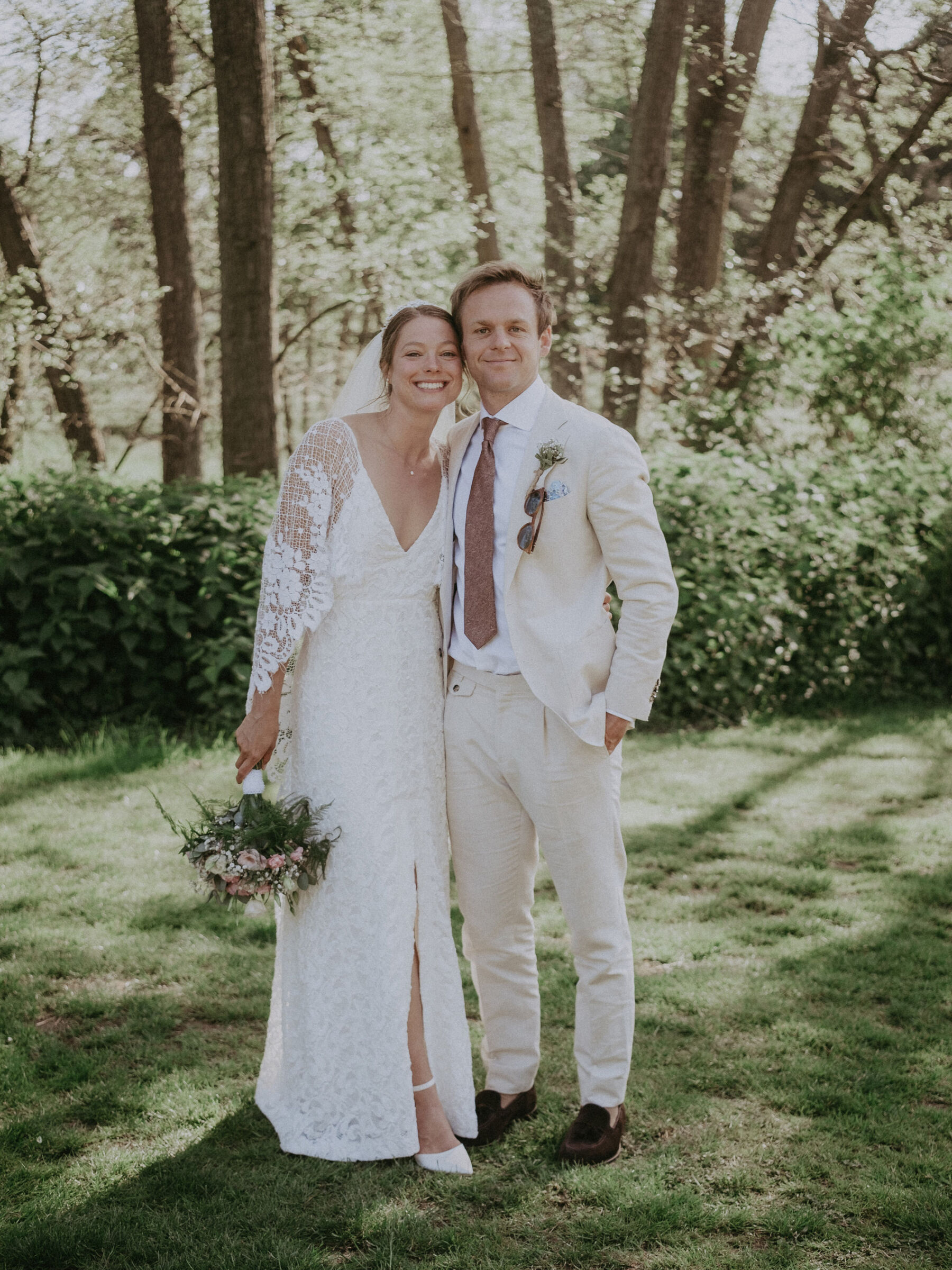 Bride wearing a Grace Loves Lace wedding dress. Groom in a pale suit.