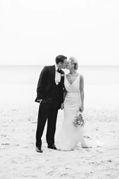Black and White wedding photo of bride and groom on the beach
