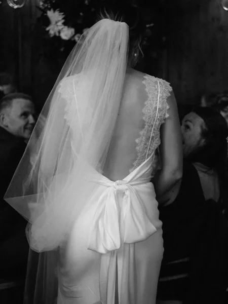 Black and white photo of back of brides dress at hedsor house