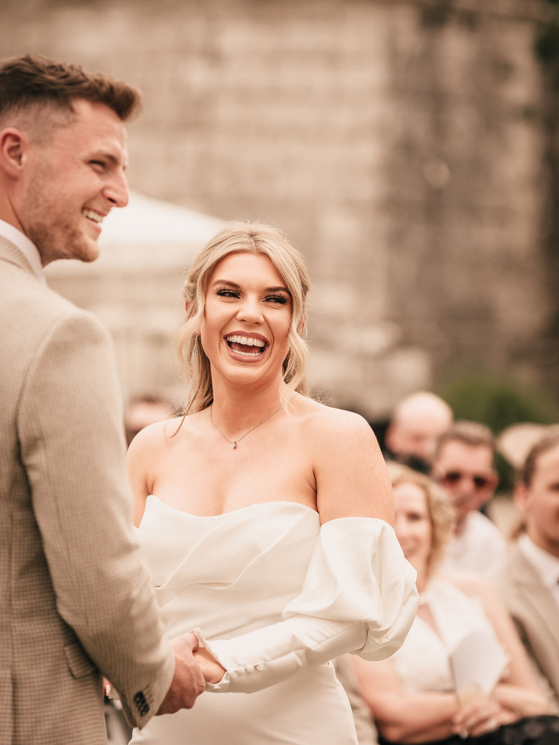 Bride in Enzoani wedding dress smiling during her outdoor ceremony in France