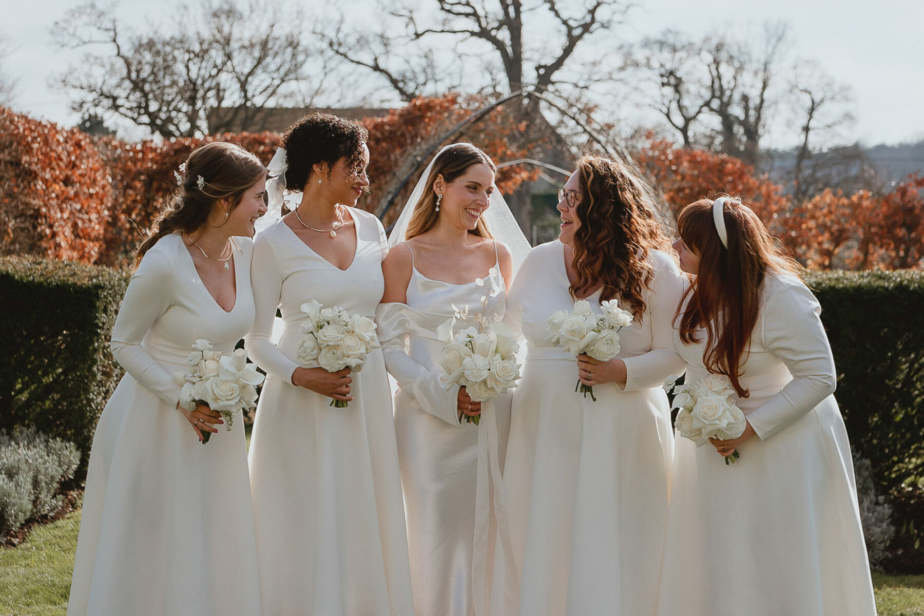 Bride in Newhite wedding dress. Bridesmaids in all white dresses from Coast.
