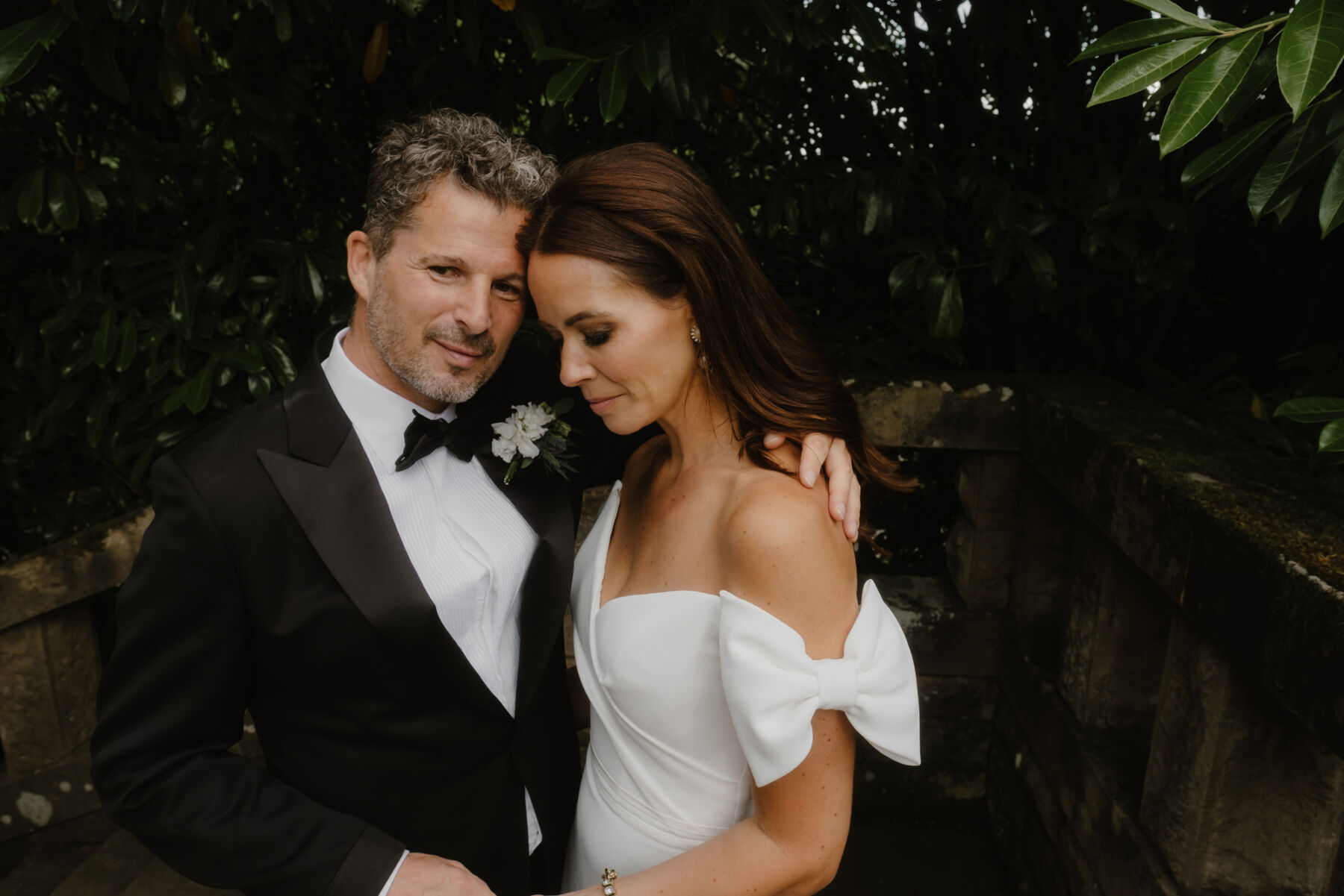 Bride with a Suzanne Neville dress with a bow on the sleeve. Groom in black tie for a wedding at Gleneagles in Scotland