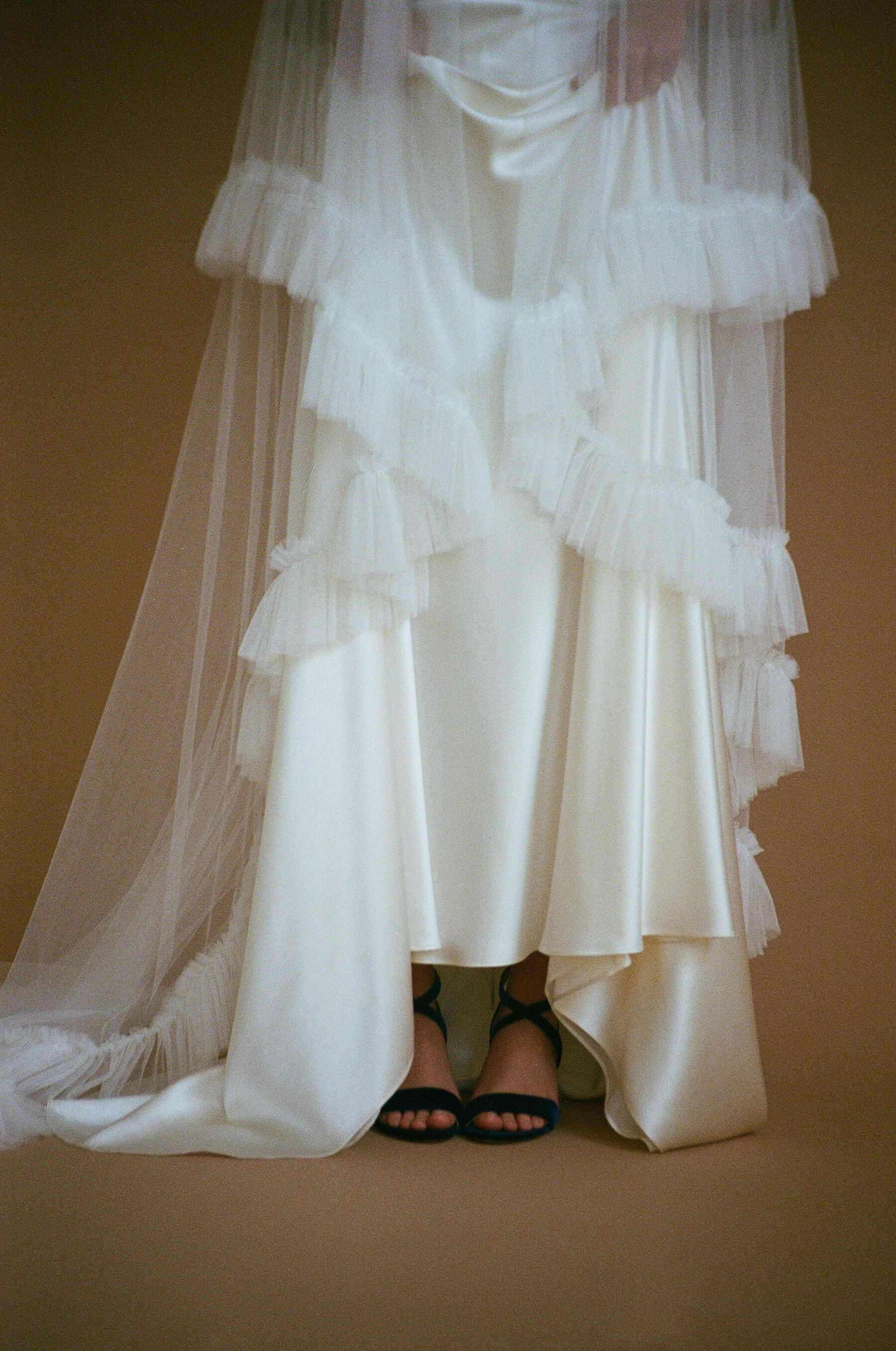 Analogue photograph of an ethical wedding dress by British designer, Kate Beaumont and frilly edged wedding veil