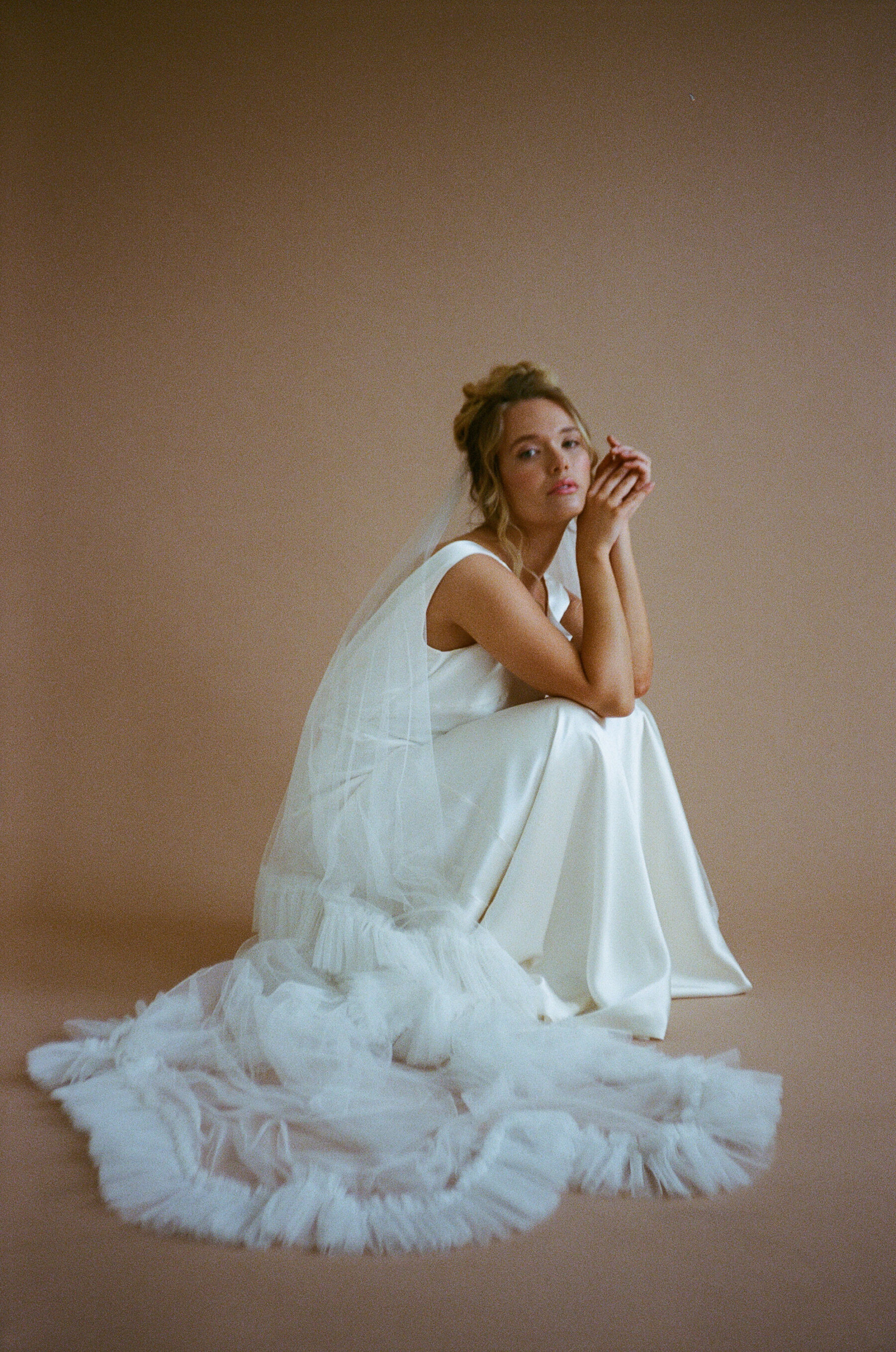 Analogue photograph of an ethical wedding dress by British designer, Kate Beaumont and frilly edged wedding veil