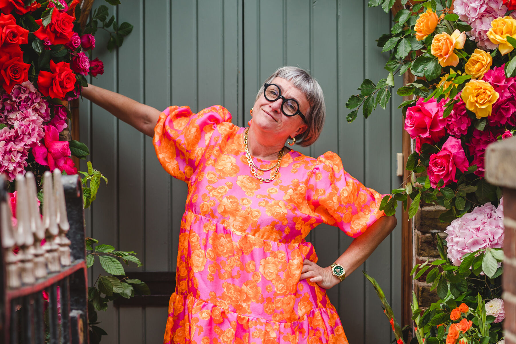 Emma Marshall of Miss Bush bridal boutique wearing a bright orange and pink floral dress.