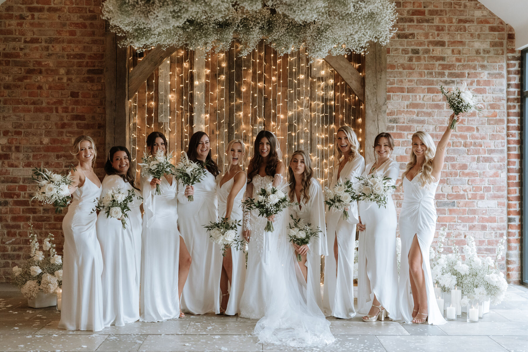 Thirsk Lodge Barns - brides with her bridesmaids dressed all in white with a fairylights backdrop at this North Yorkshire wedding venue