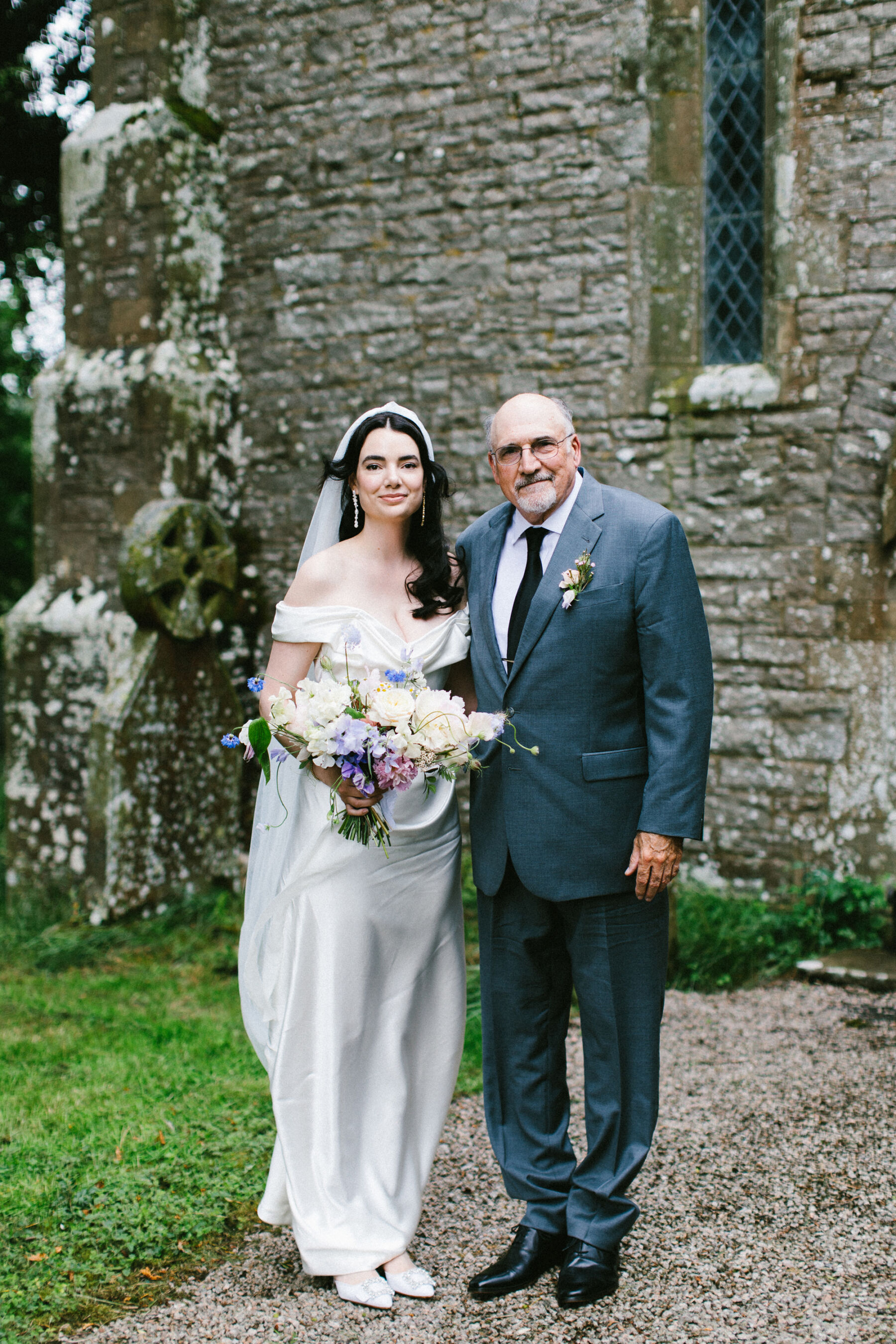 Father of the bride in a slate blue suit with the bride wearing a Vivienne Westwood dress.