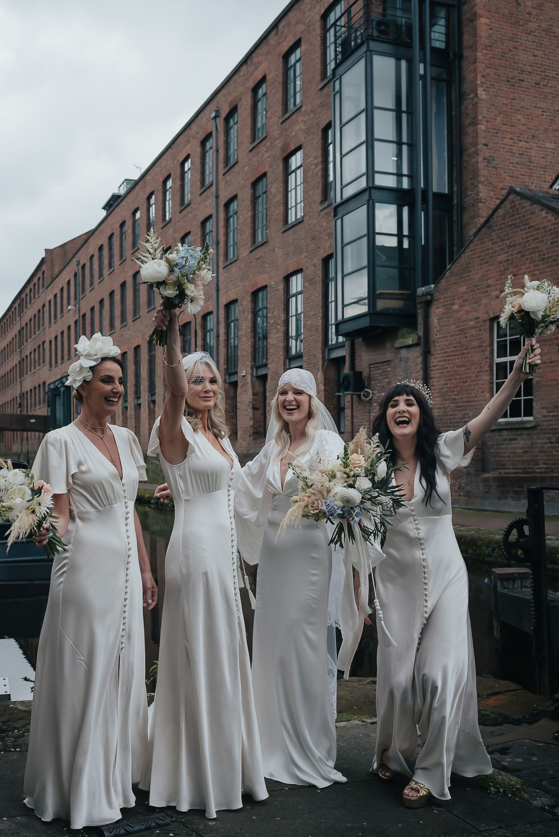 Bride in modern Rue de Seine wedding dress surrounded by bridesmaids in white