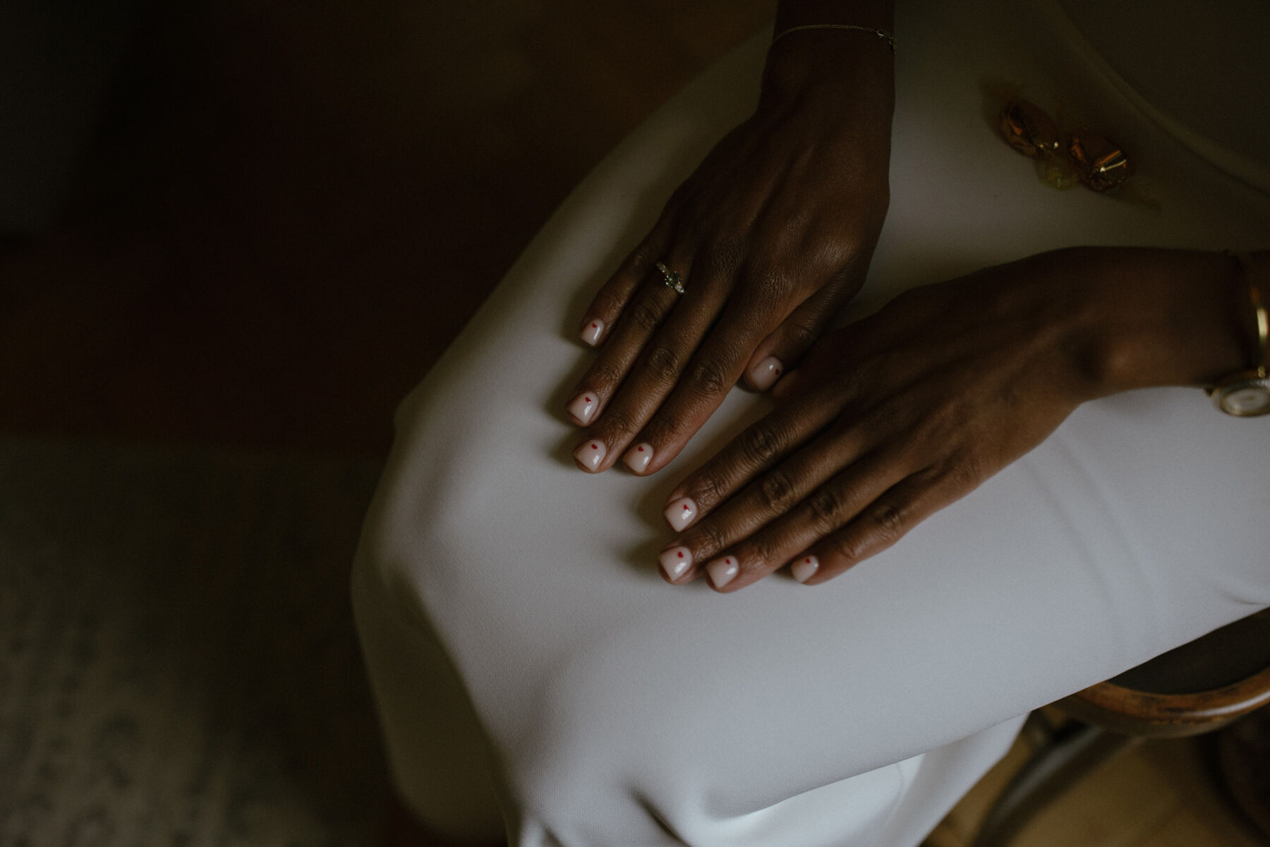 Close up shot of a Black bride's manicure - pale polish with tiny red hearts. Ruth Atkinson Photography.