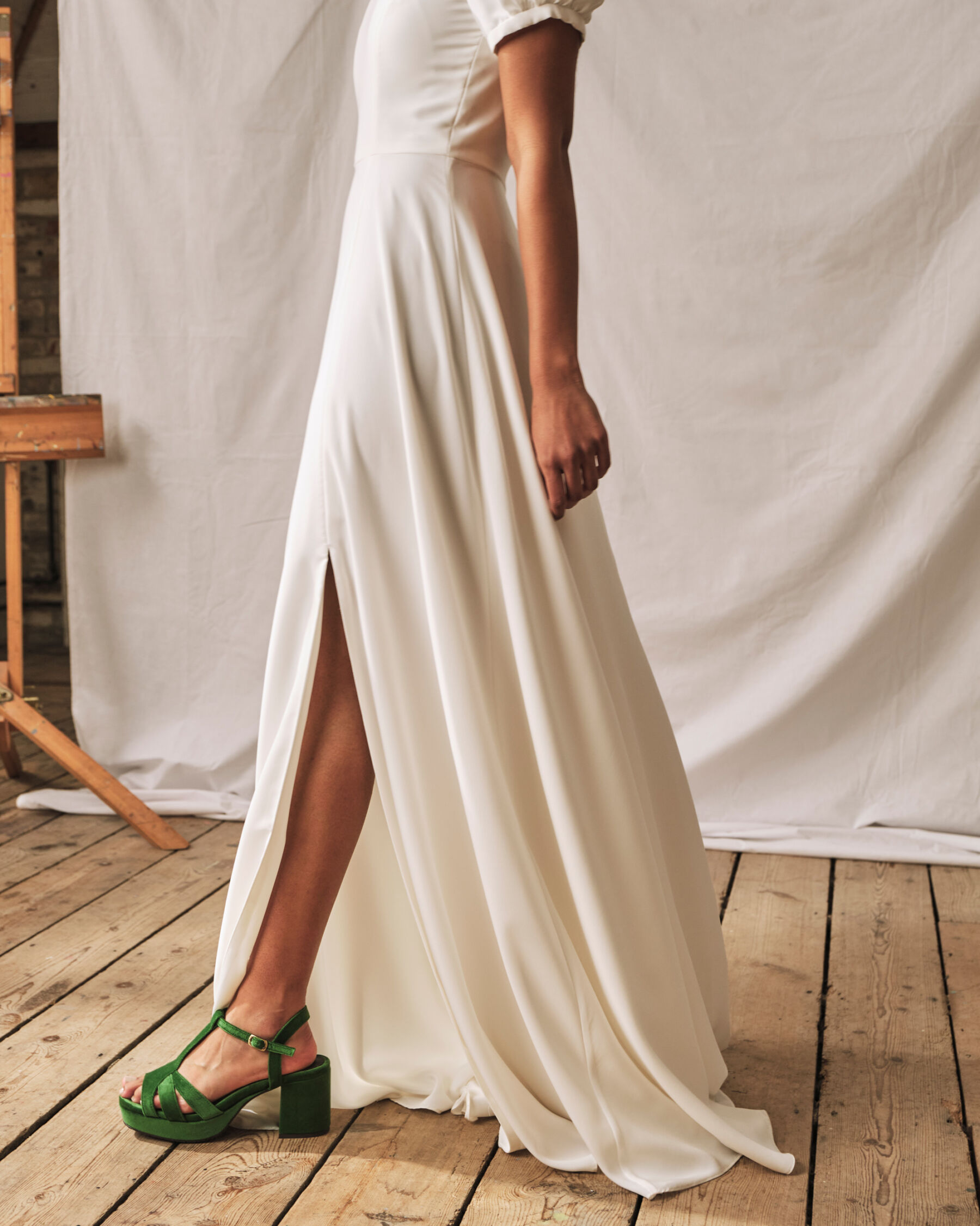 Simple wedding dress with knee split, worn with green block heel shoes by Esska.