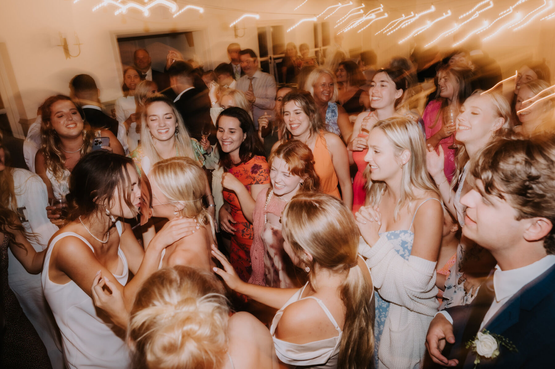 Wedding dance floor full of guests dancing all happy and joyful. 