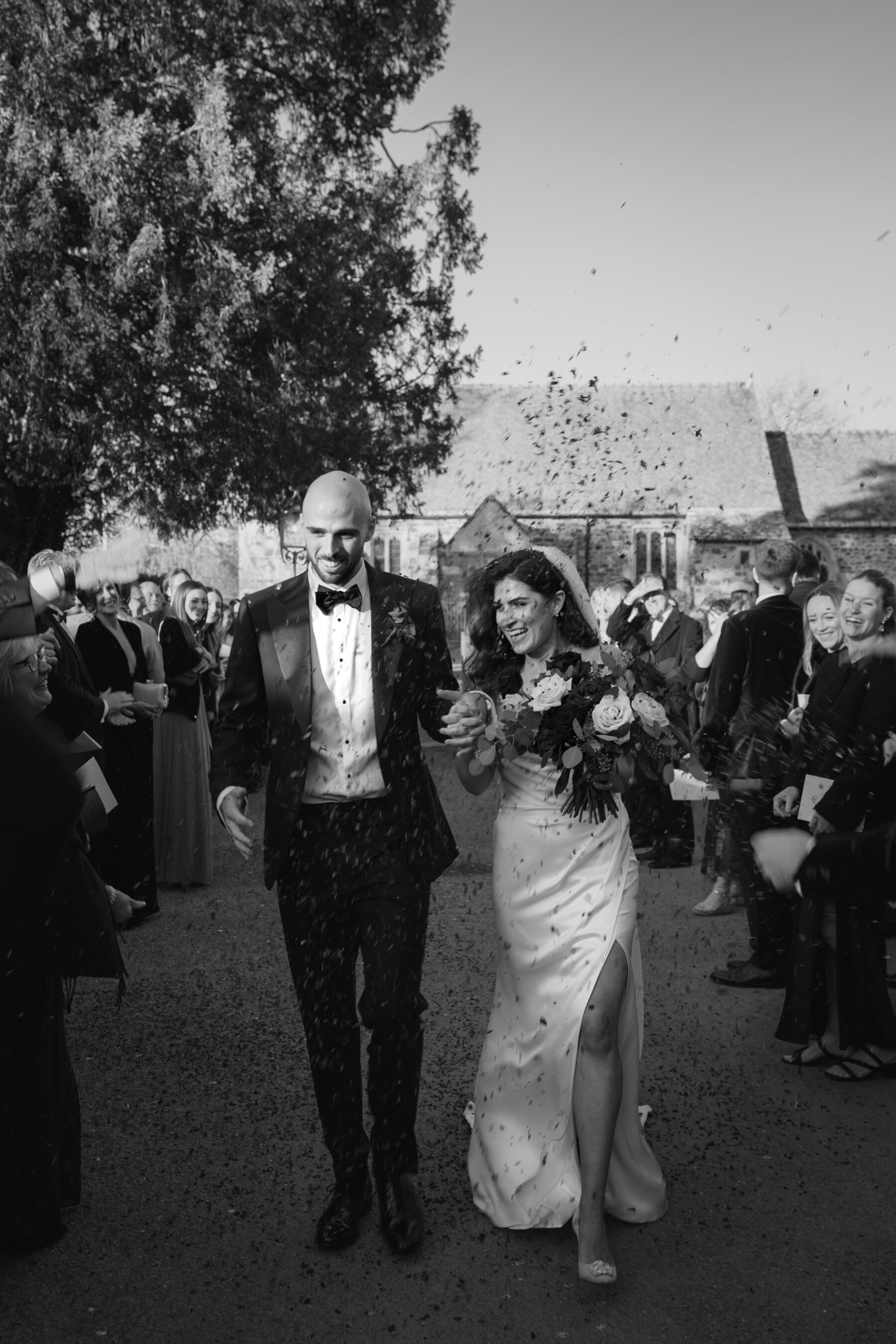 Bride and groom exiting their wedding ceremony in a shower of Confetti at Somerley House in Hampshire