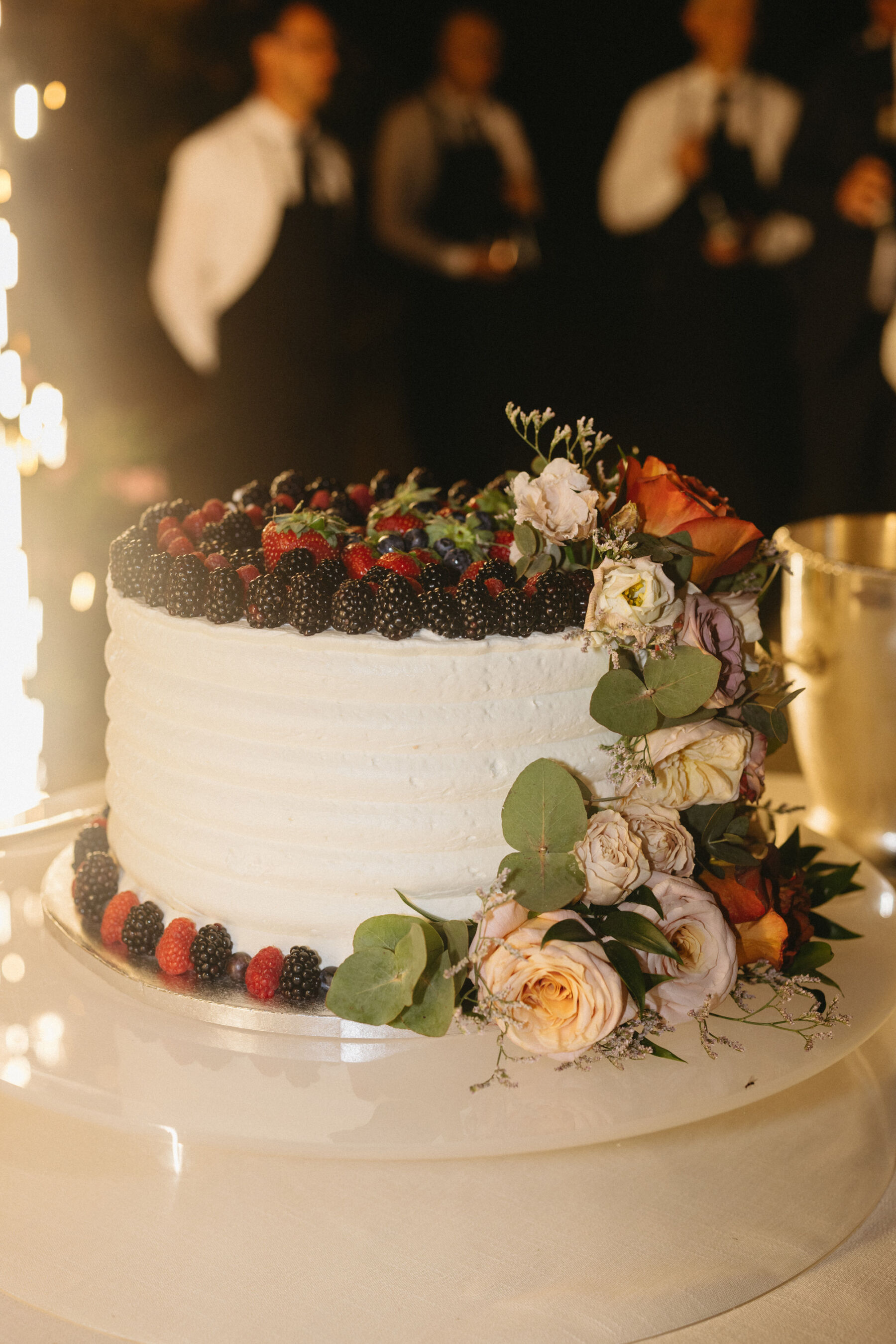 Single tier wedding cake topped with berries.
