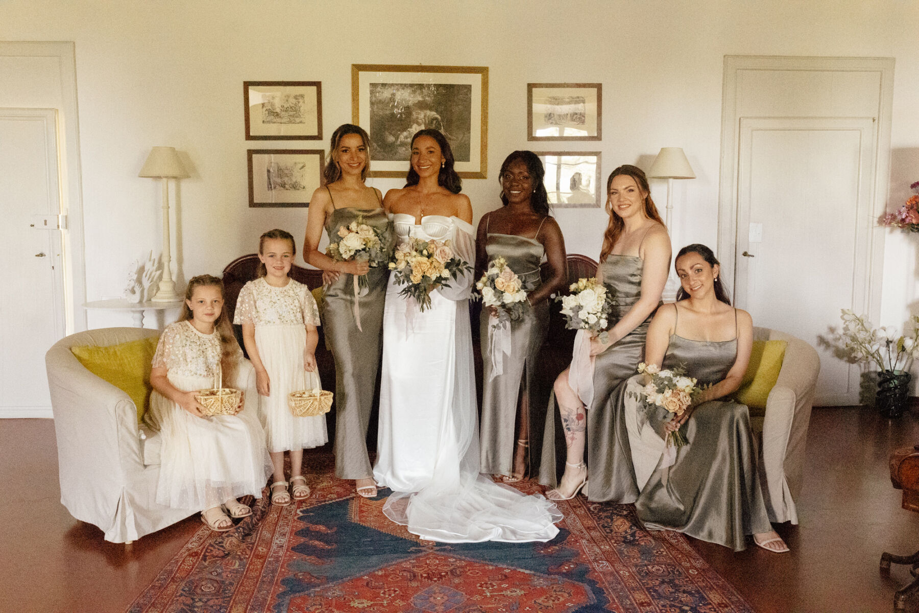 Bride in an Alena Leena wedding dress, surrounded by her bridesmaids in pale green dresses by Bec & Bridge, and flower girls wearing Needle and Thread dresses.